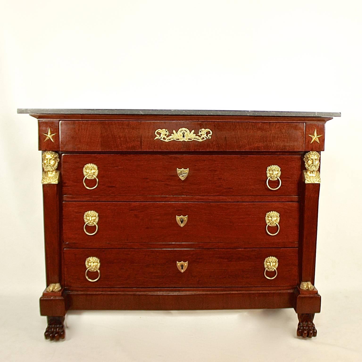 A fine Empire acajou mouchete mahogany commode in the manner of Bernard Molitor (1755-1833). A rectangular oak corpus veneered with acajou mouchete mahogany, with a grey marble top above a projecting frieze drawer adorned with five-pointed stars,