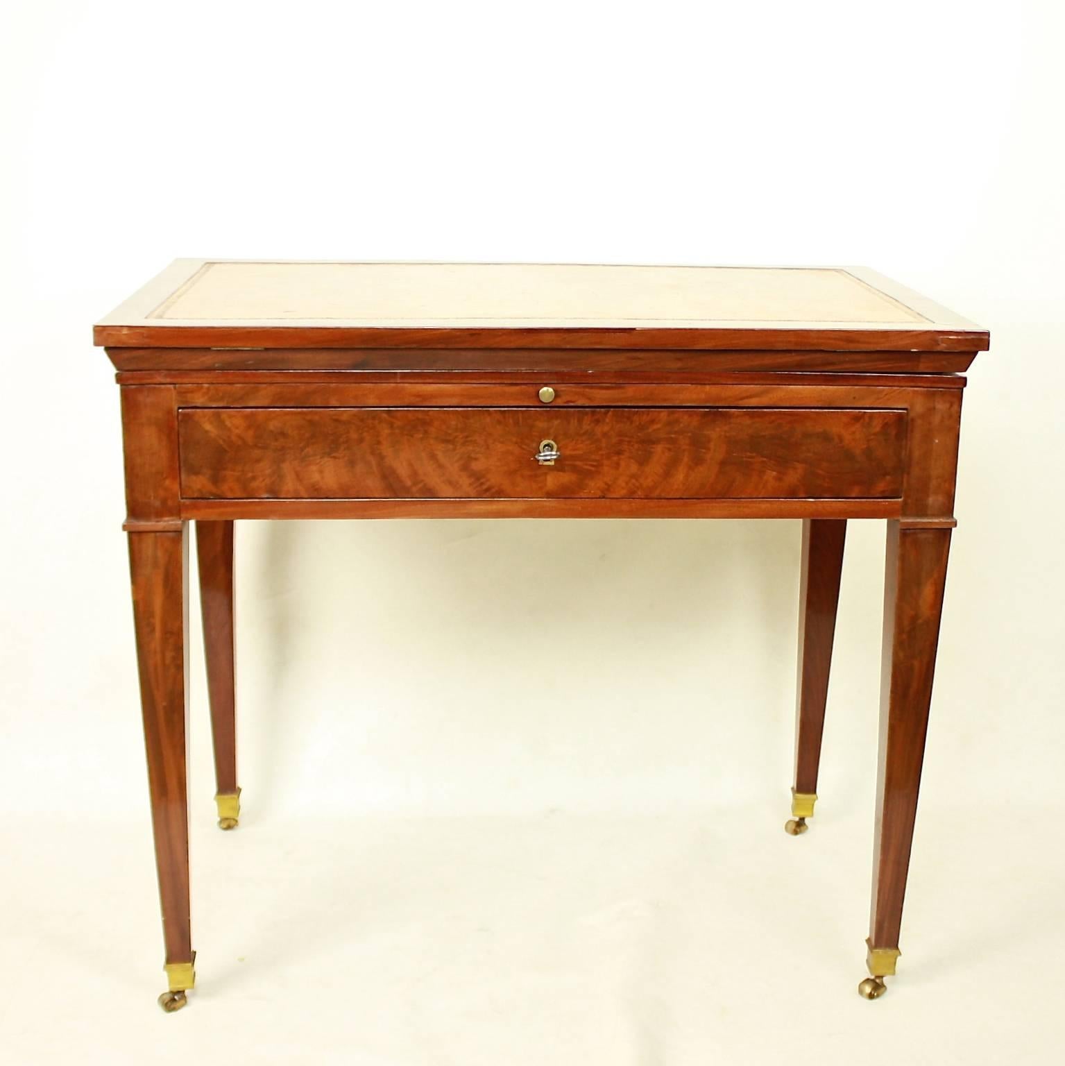 A late 18th century Directoire mahogany architect's table. A mechanical table with a double-hinged ratcheted top and the original gold-tooled brown leather lined writing surface, veneered in beautifully, if rather pale, flame-grained polished