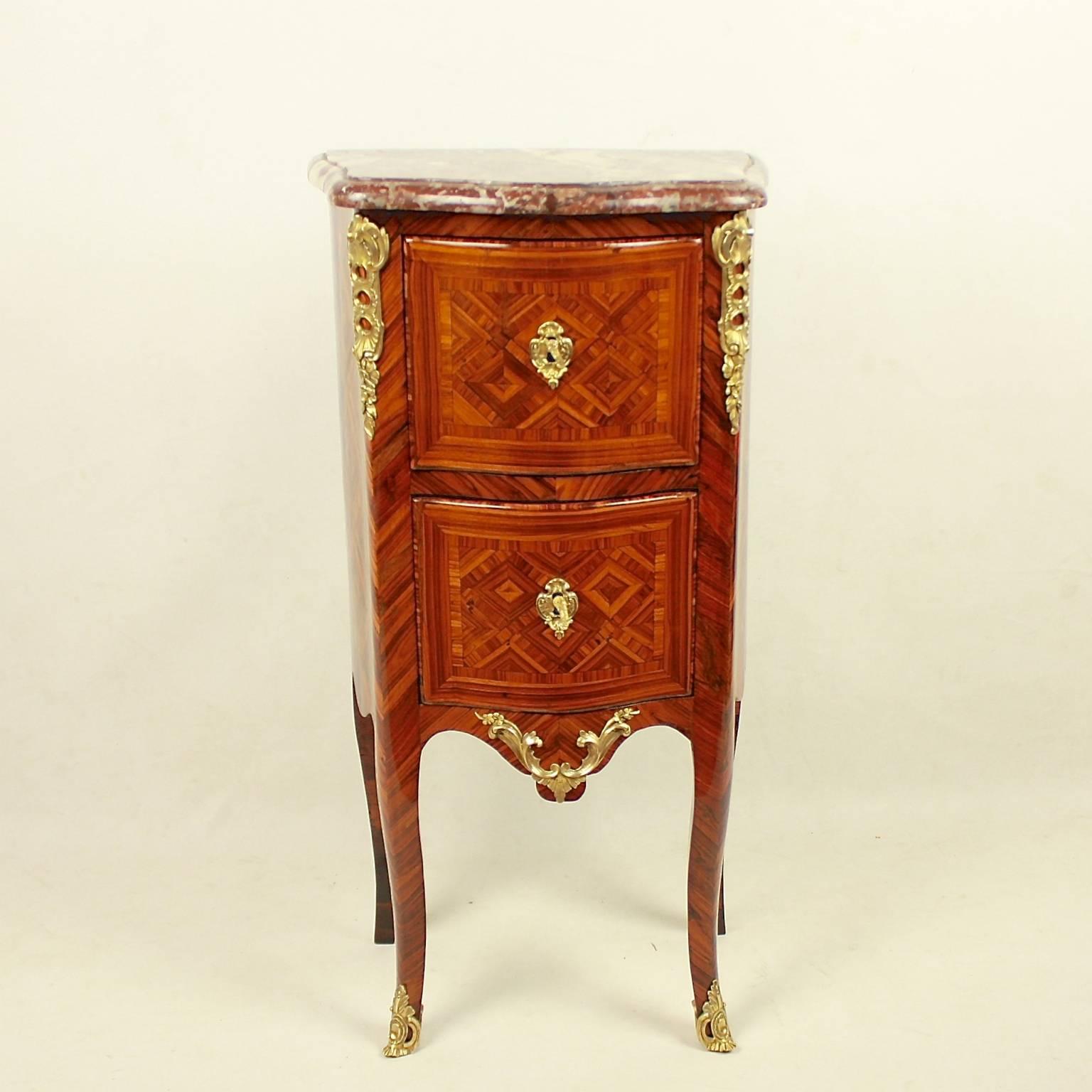 A rare small tulipwood and parquetry commode with gilt bronze mounts in the manner of Mathieu Criaerd (1689-1776).
The commode of serpentine form with a moulded russet marble top above two drawers, with rounded corners, the whole inlaid with cube