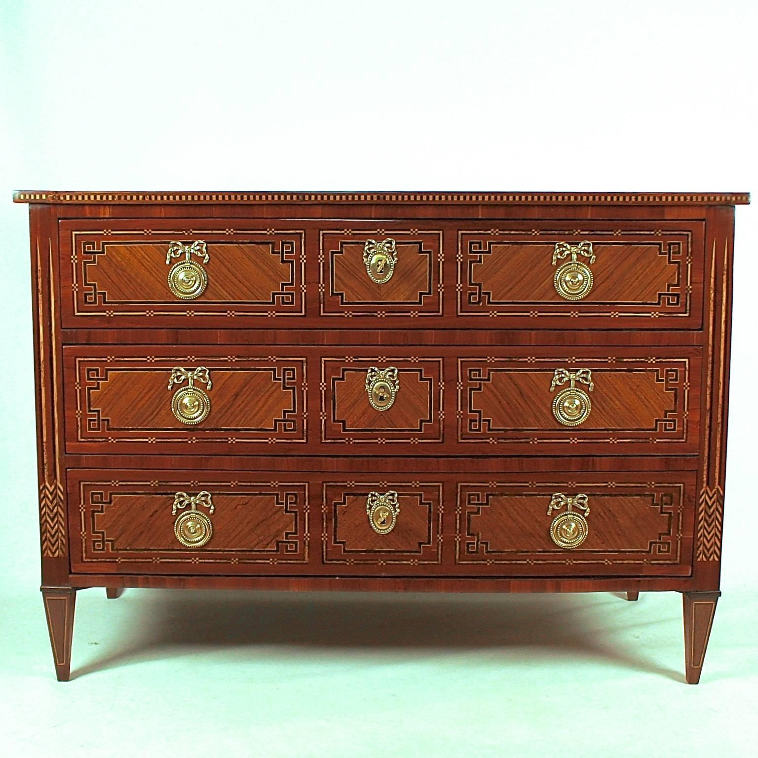 Fine Eastern French Louis XVI chest of drawers or commode of high craftsmanship. The three-drawer pinewood carcass veneered in walnut, plum, maple and other woods. The drawers with three mirror-veneered panels, with checkered inlaid banding and