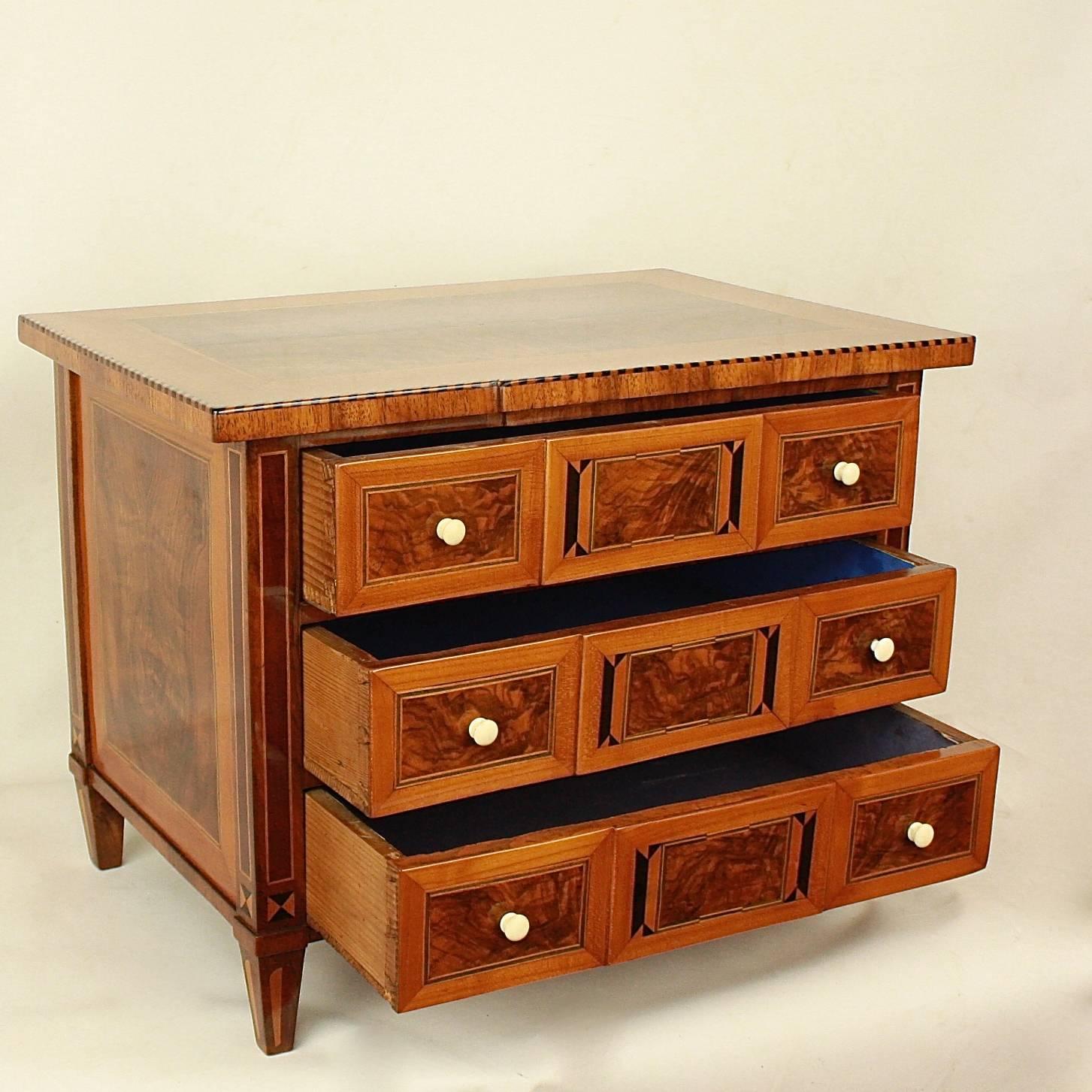 An 18th century Louis XVI miniature marquetry commode, a scaled replica of a Louis XVI chest of drawers. With a veneered top above three drawers of breakfront form, with very fine marquetry and banding using ebonized wood, walnut, mahogany and