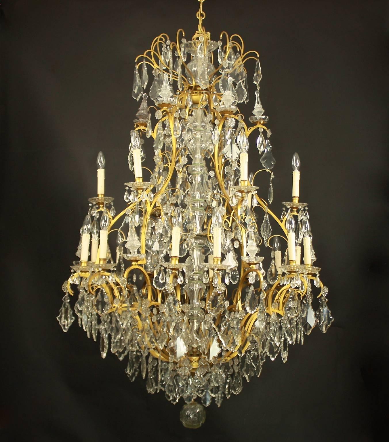 This exceptional and very large (7ft 3 inches) French gilt-bronze chandelier has a massive central cut-glass baluster stem ,a Vase-d'enfilade, and is surrounded by an undulating pear-shaped cage frame with two tiers issuing 18 candles, each with