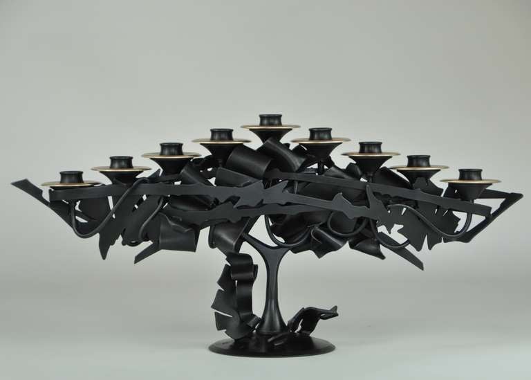 Albert Paley (born 1944)
Menorah, 2013
Formed and fabricated blackened steel, brass
Measures: 11 x 22 inches
Signed, dated and numbered at base
Edition of 18 (plus 2 artist’s proofs) 

Albert Paley, an active artist for over forty years at
