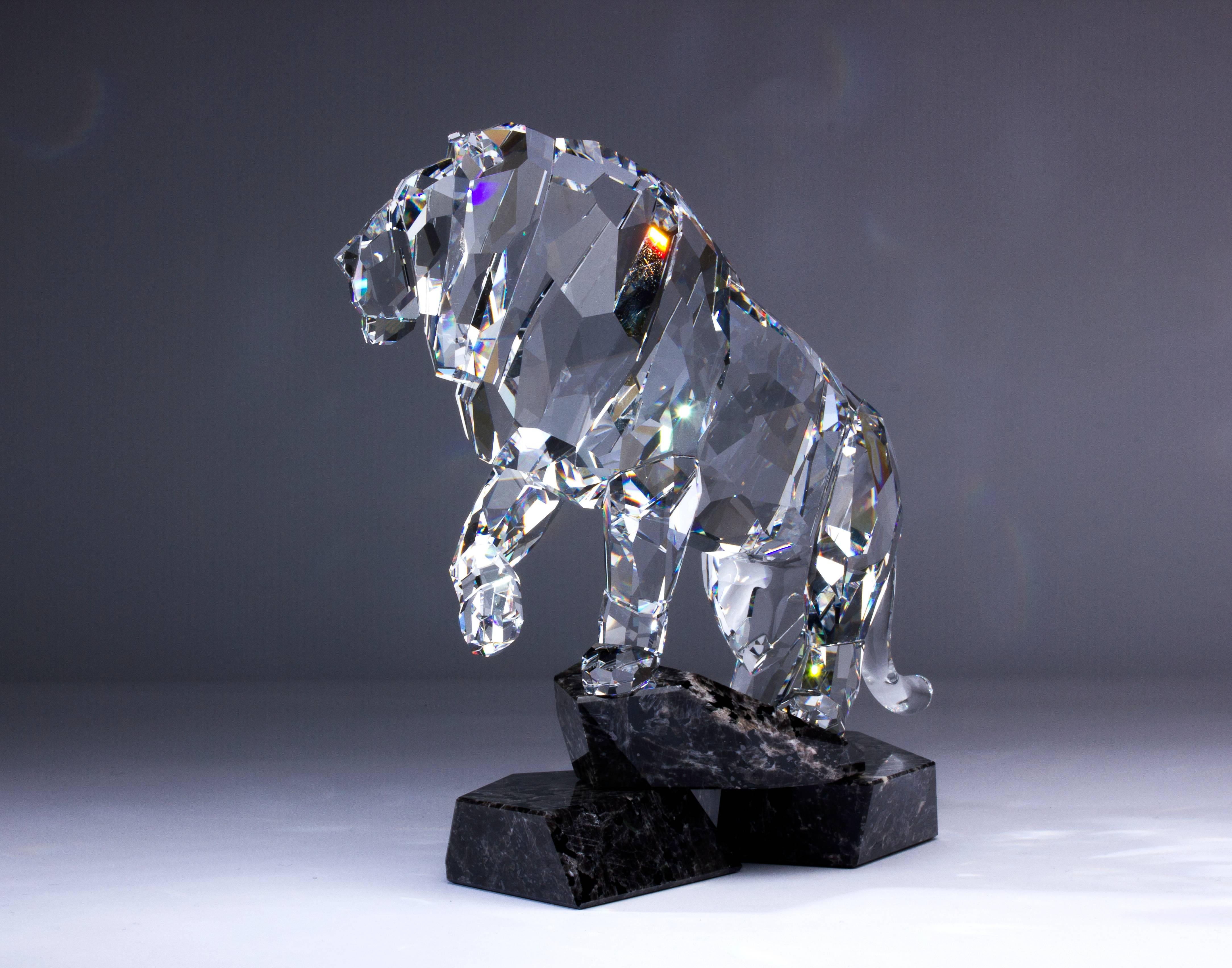 Proud, brave and majestic, the lion symbolizes the spirit of nobility. A rising pose of the royal leader has been beautifully captured in 24 crystal pieces. The strong lion stands on a three-pieced cut mahogany granite base. In clear crystal, the