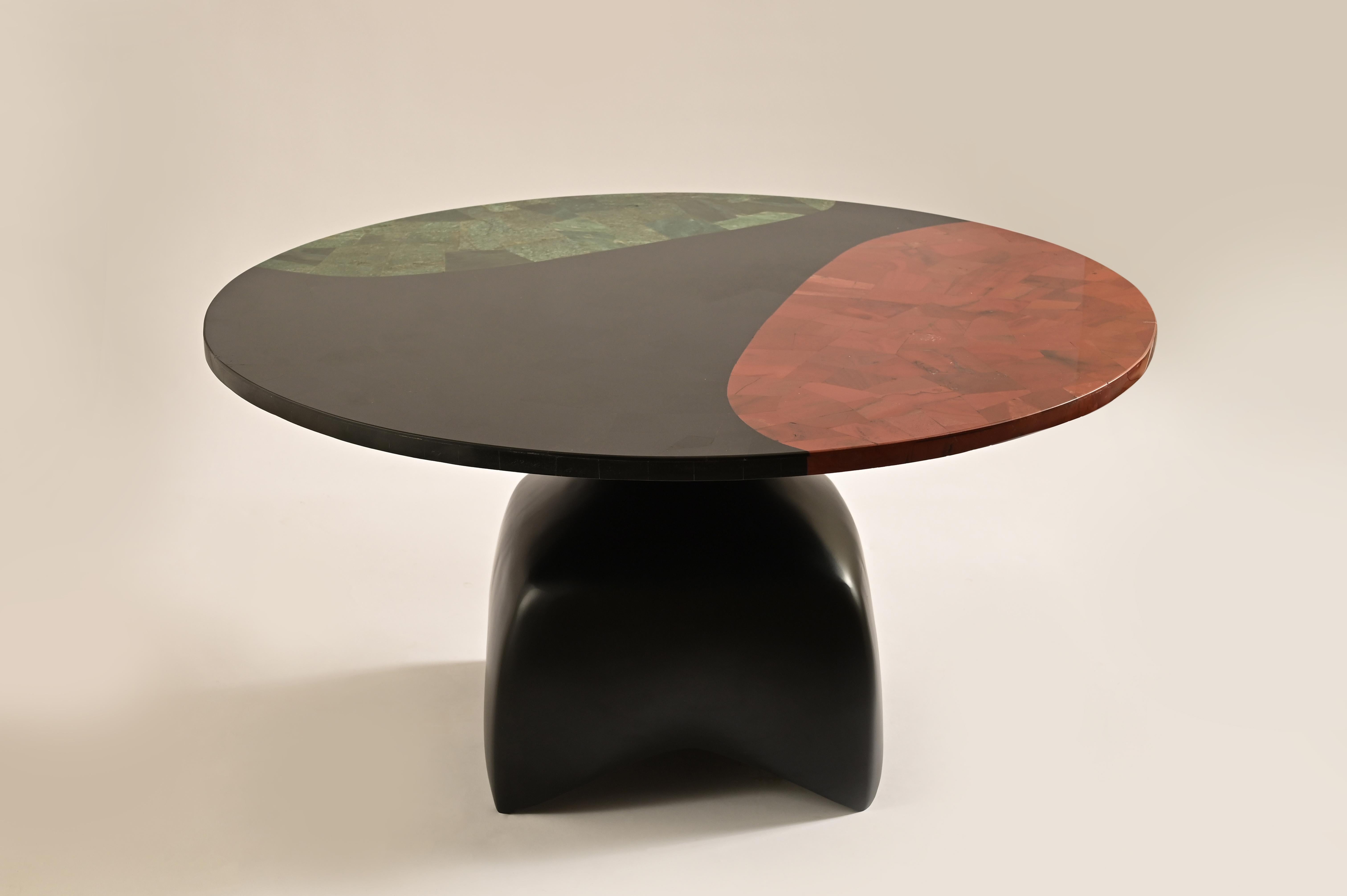 Der Couchtisch Jasper ist ein fesselndes Meisterwerk aus Halbedelsteinen. Das Oberteil, eine faszinierende Mischung aus rotem, schwarzem und grünem Jaspis, ist eine Symphonie aus Farbe und Textur. Jeder Stein, ein einzigartiges Instrument, trägt