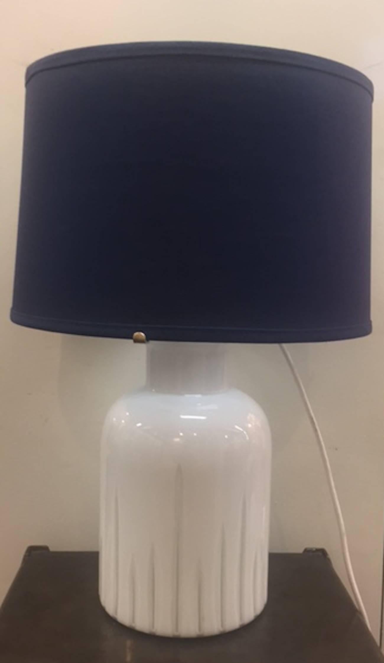 A beautiful vase shape base table lamp made in Italy circa 1970-1980 in the manner of La Murina of Murano. The white base is blown in clear over white over clear glass and etched with vertical lines. There are two light sockets. One in the base to
