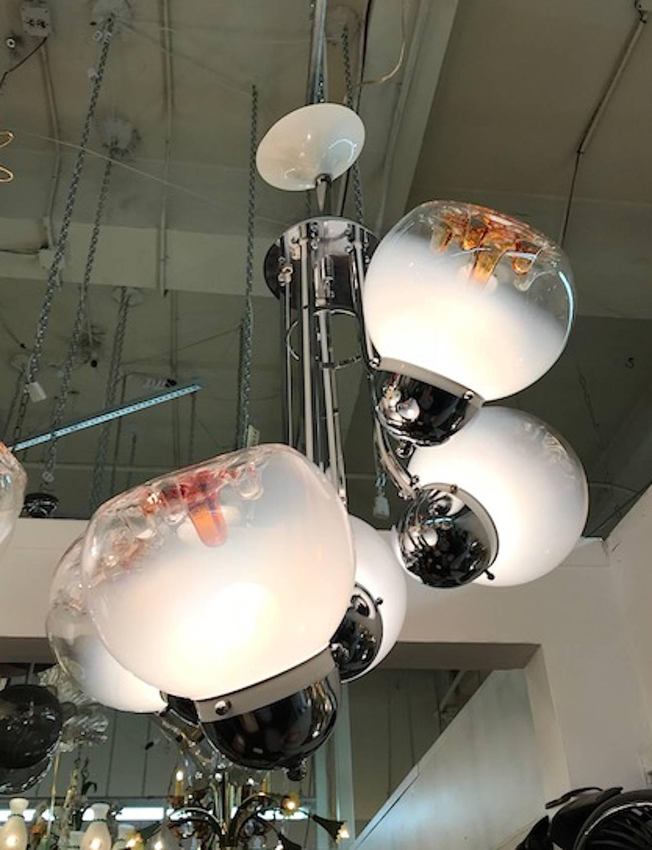 Italian 1970s modern chrome, white enamel and glass sculptural chandelier. Each globe of hand blown glass in white, clear and amber color from Murano.
Price per Item.