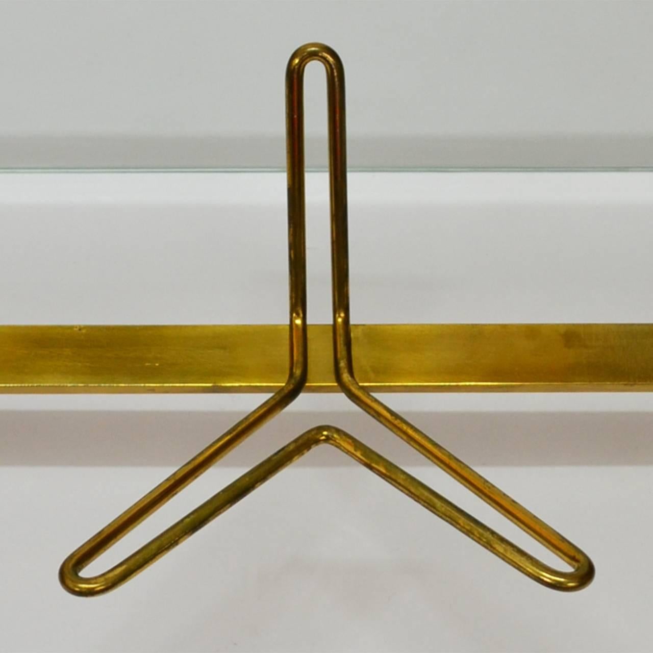1950s wall-mounted coat hooks, wood support, brass, glass shelf on top.
Good original condition.