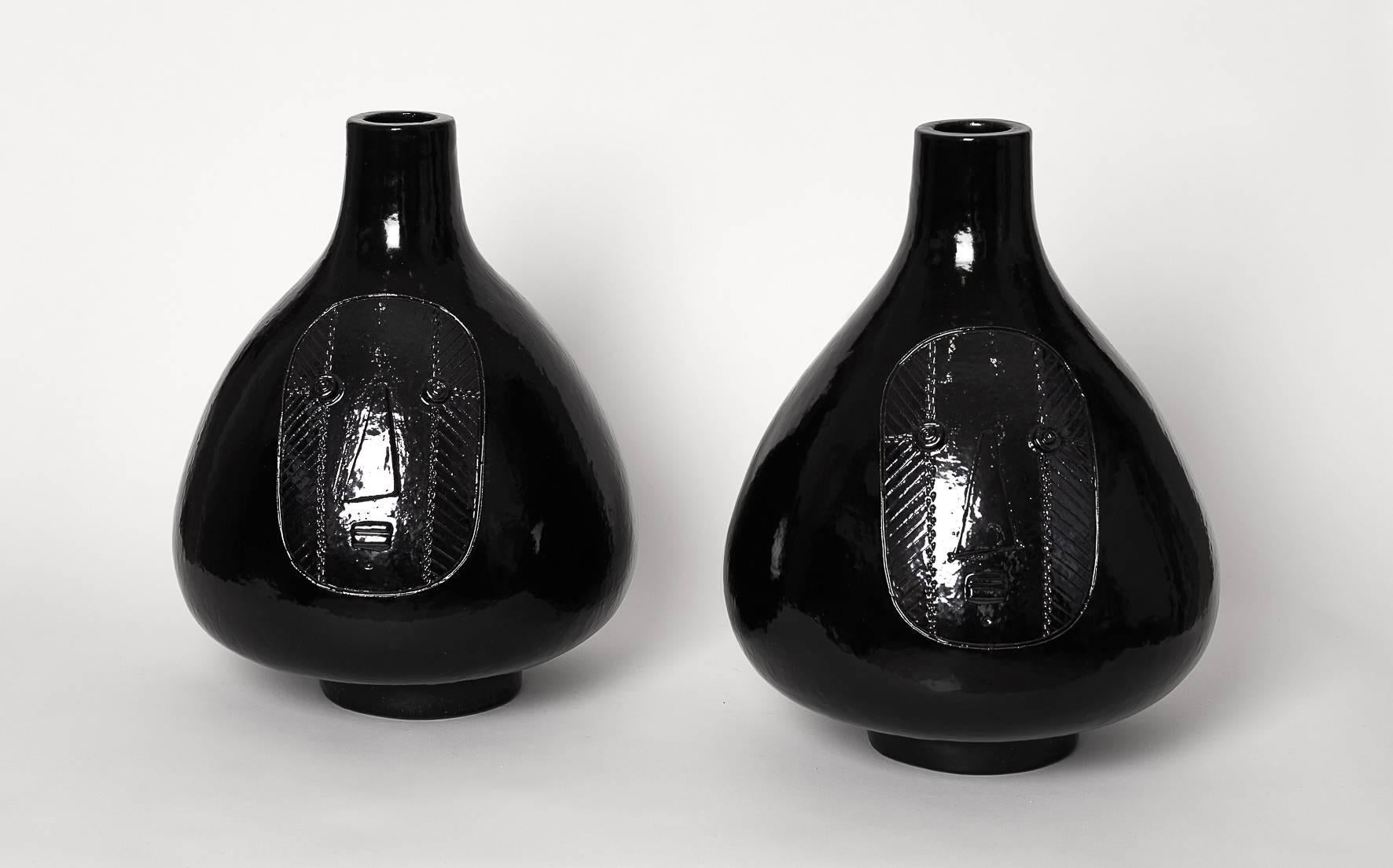 Large pair of lamp-bases, stoneware glazed in deep black with decoration of faces engraved. 
Unique pieces signed by the French artists. 

 Height dimensions approximate are without the electrical socket system on top and without the