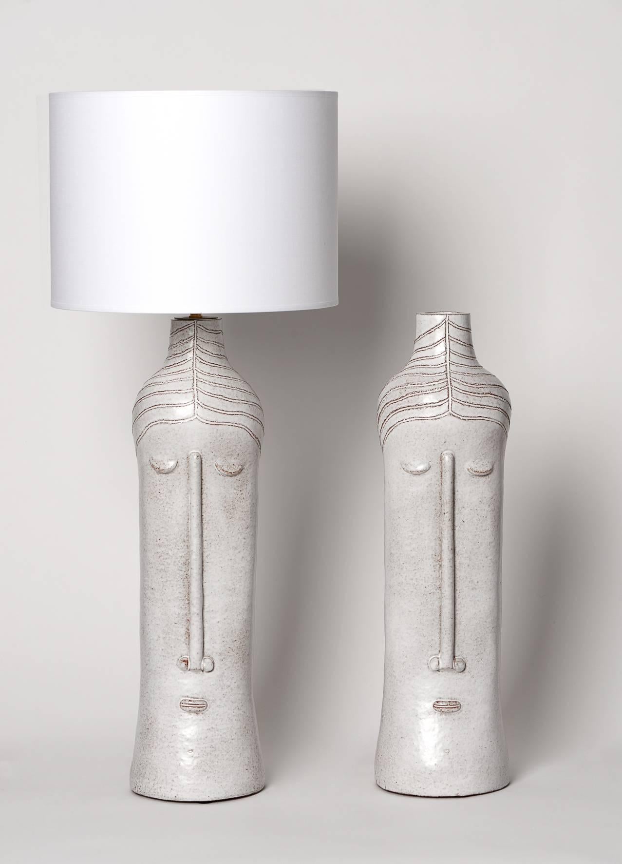 Pair of ceramic base lamps with stylized faces in beige glazed enamel.
Unique pieces signed by the French artist Dalo, 2016. 

 Note: Our clients will handle to install the electrical system by their local and professional electrician (refer to