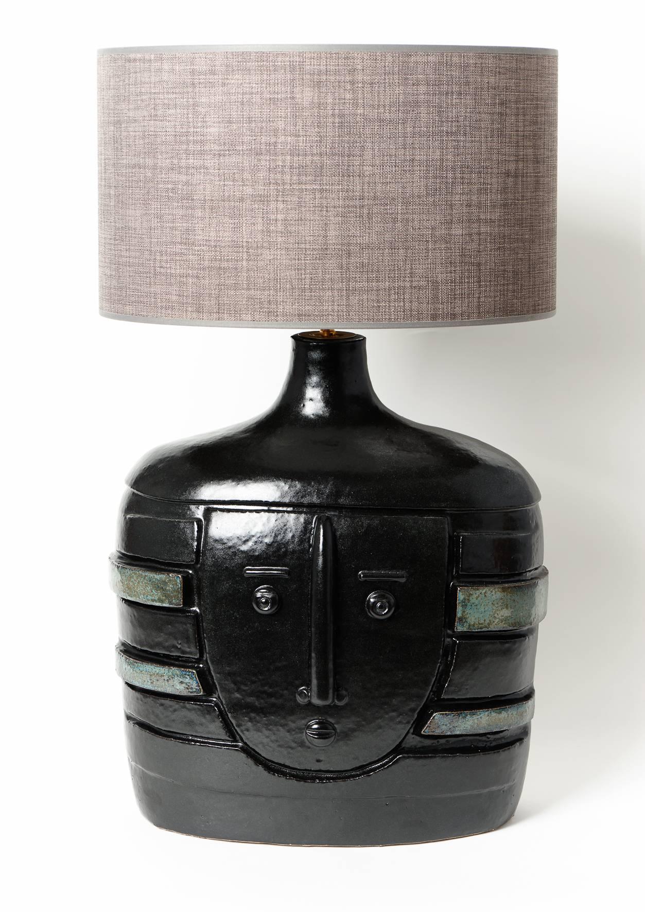 Large hand-sculpted ceramic lamp base, stoneware glazed in shiny black, decorated with a biomorphic visage sculpted and incised, and green stripes on sides.
One of a kind handmade piece signed by the French ceramicists DALO. 

The height dimension
