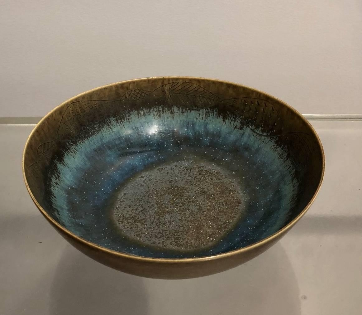 Stig Lindberg for Gustavsberg, Sweden.
Unique stoneware bowl with different brown and blue glaze, round of engraved fishes, look as a lake.
Measures: Height 6 cm, width 21 cm
Incised "G (hand) Stig L."
Excellent condition, no chips,
