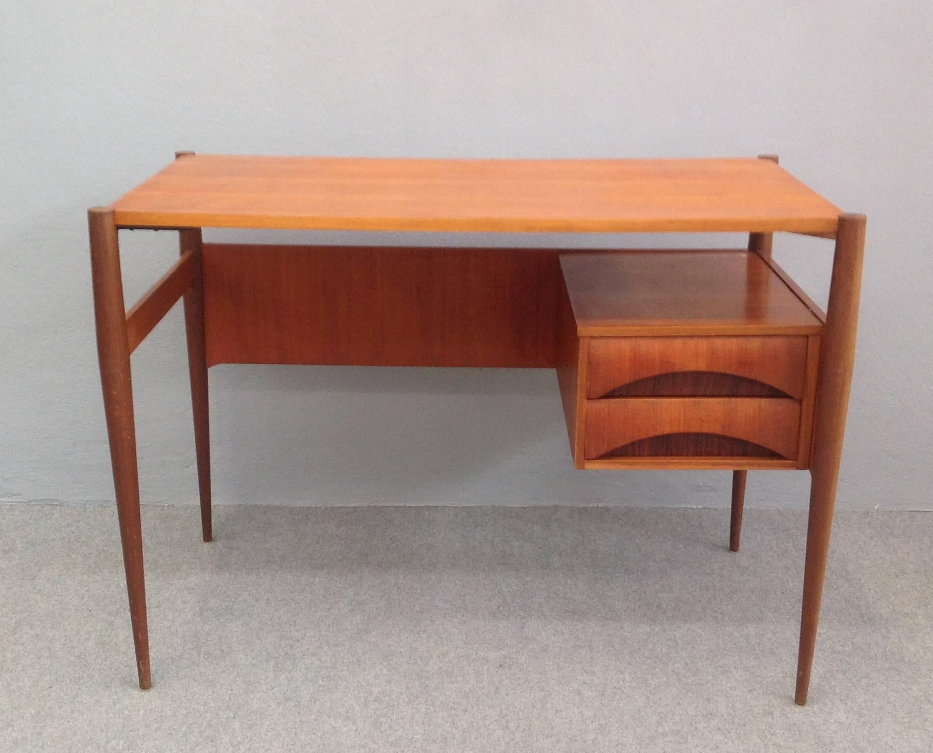 Two flanking drawer desk, finished on all sides and having storage space above drawers.
