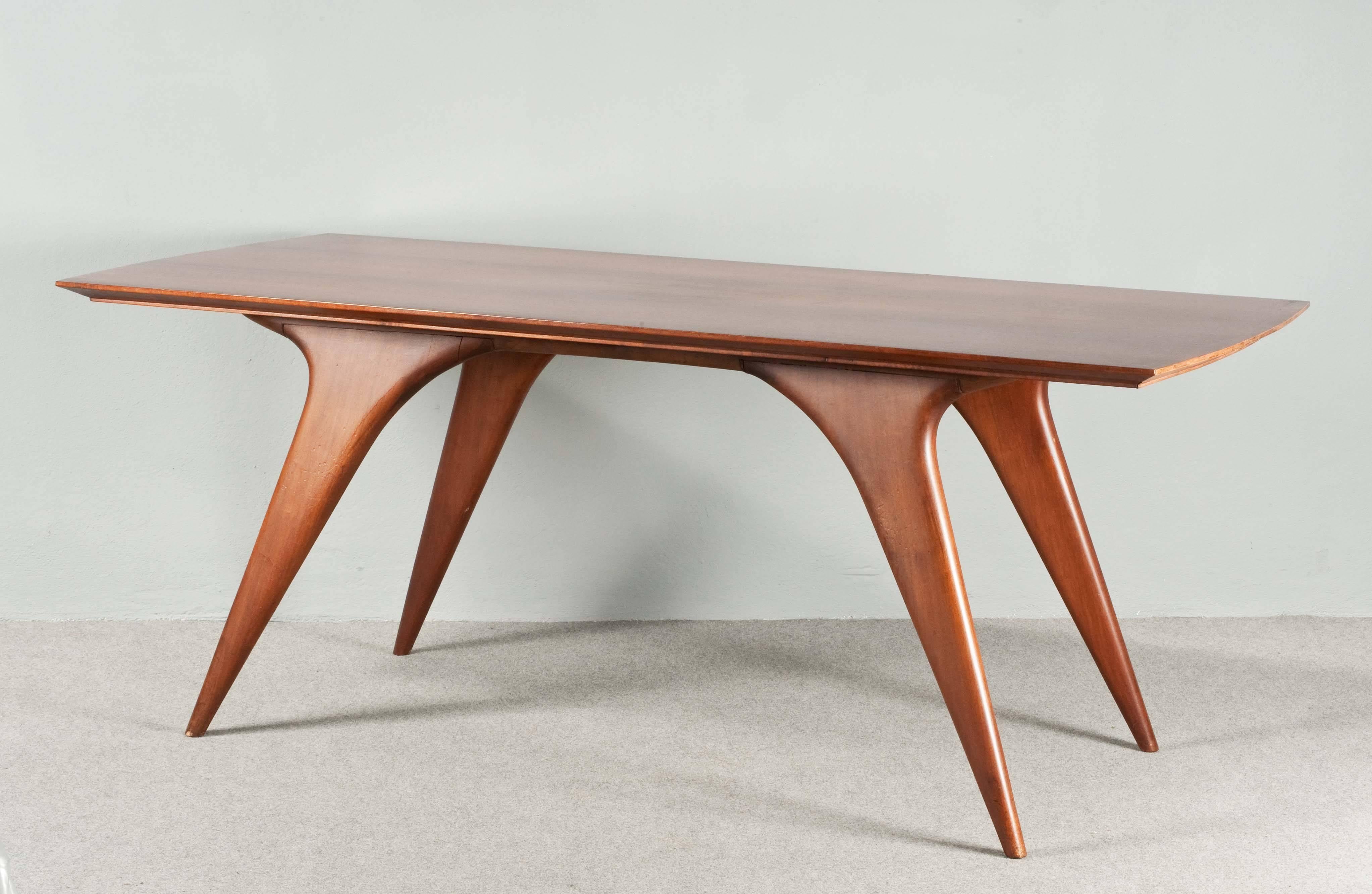 Elegant Italian walnut dining table with four wonderful shaped legs.