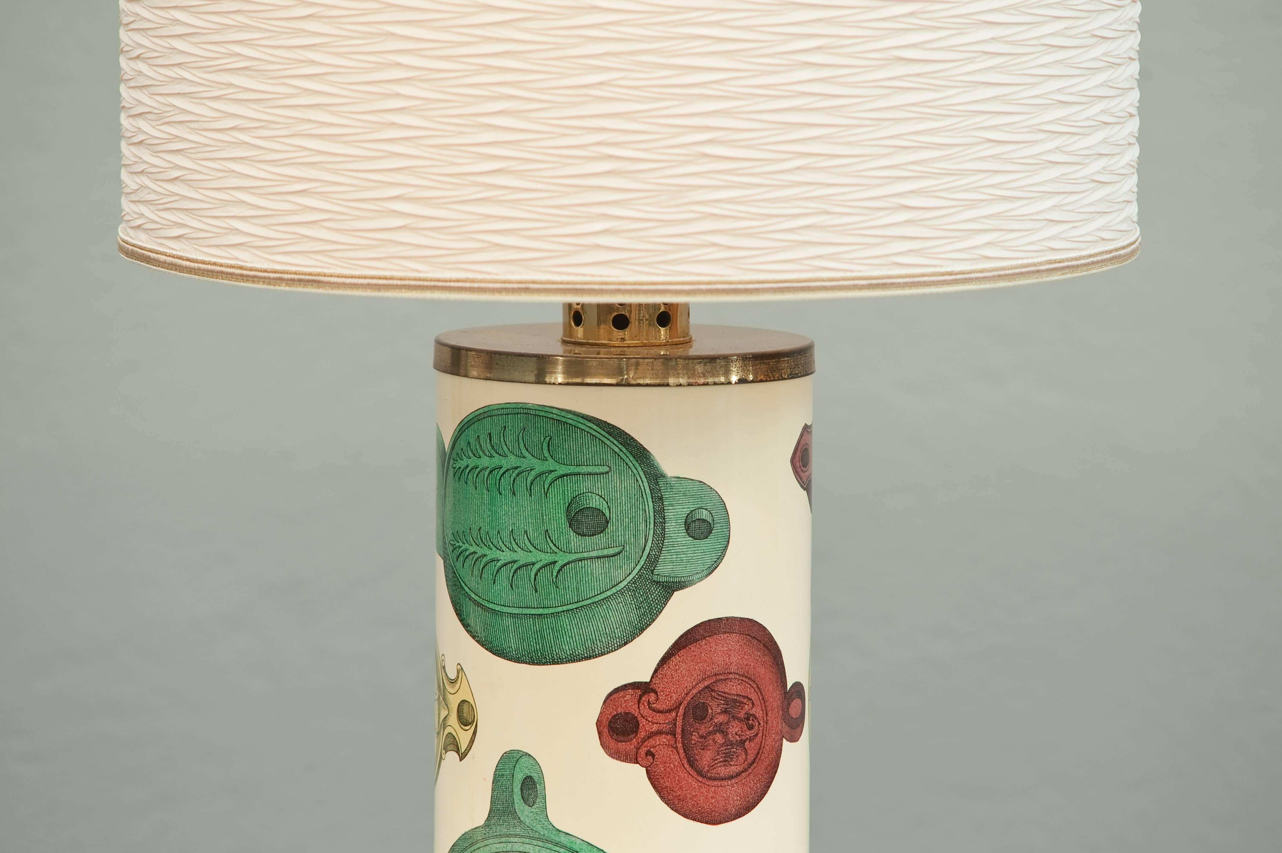 Enameled metal table lamp with printed lithographic antique lanterns with brass top and bottom.
Signed with early label.