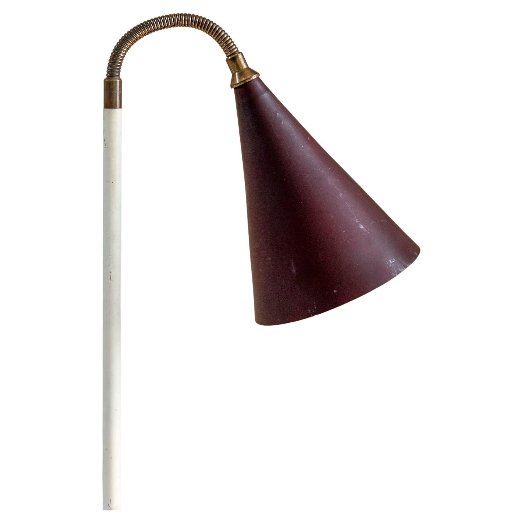 Stunning Mid-century floor lamp attributed to Giuseppe Ostuni.
The lamp consists of a marble base that support a white enamelled metal rod with brass details. 
The original lampshade is also made in lacquered purple metal and is adjustable in
