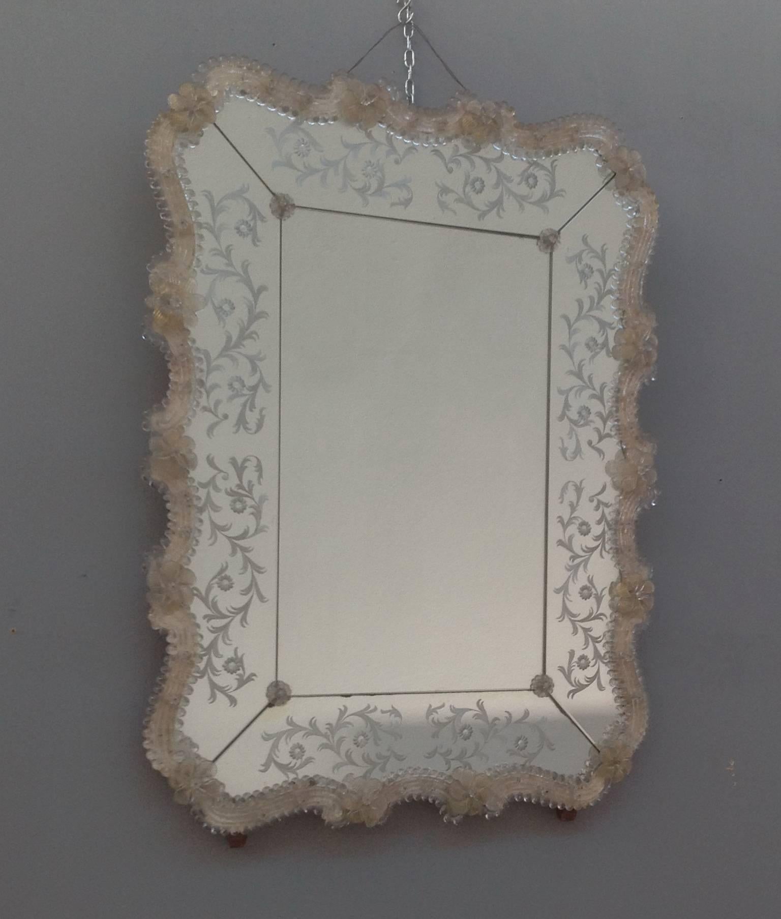 Lovely Murano glass mirror with floral accents and etching.
Perfect ondulated frame in clear glass with gold inclusions and accented by glass flowers.