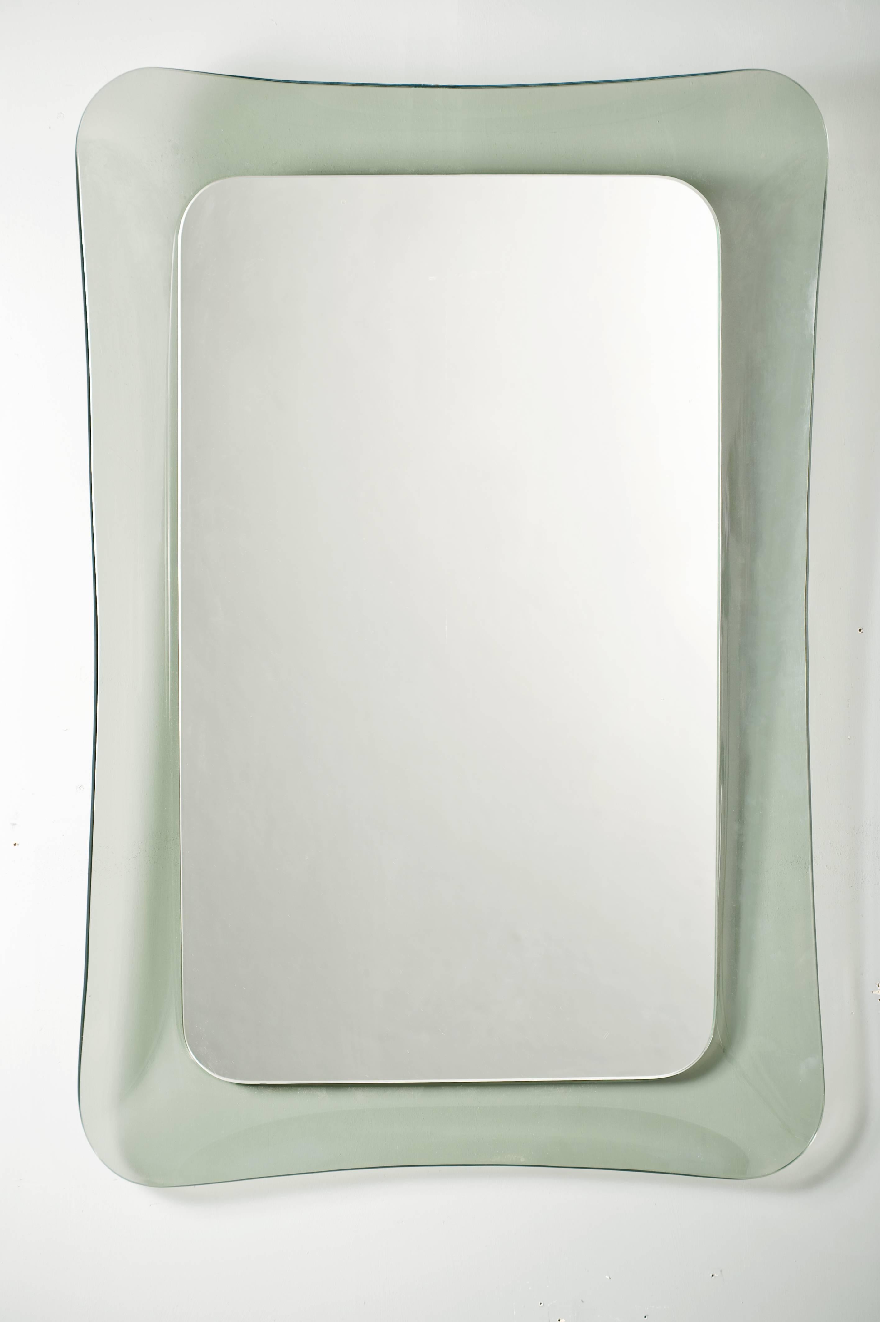 Extraordinary wall mirror with very elegant shape.
Concave light green glass frame.