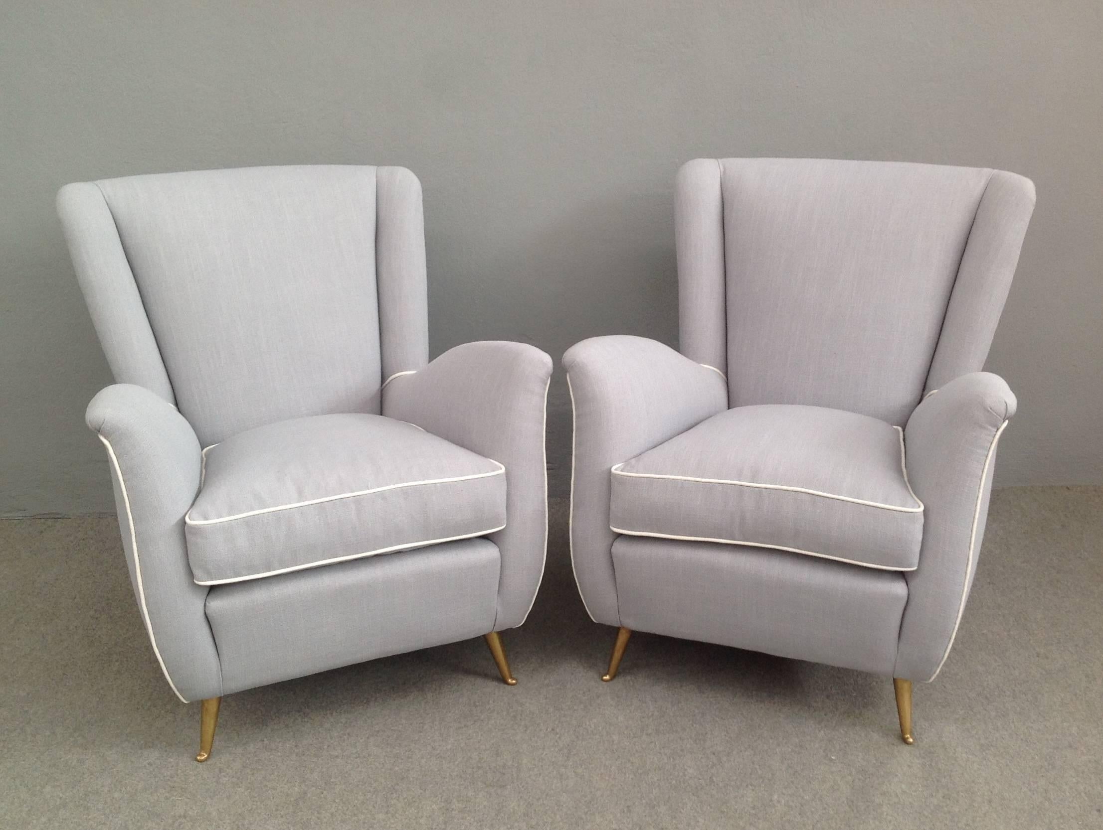 Extraordinary pair of armchairs with brass legs in the manner of Gio Ponti.
Manufacturer Isa. Newly upholstered with grey and white linen.