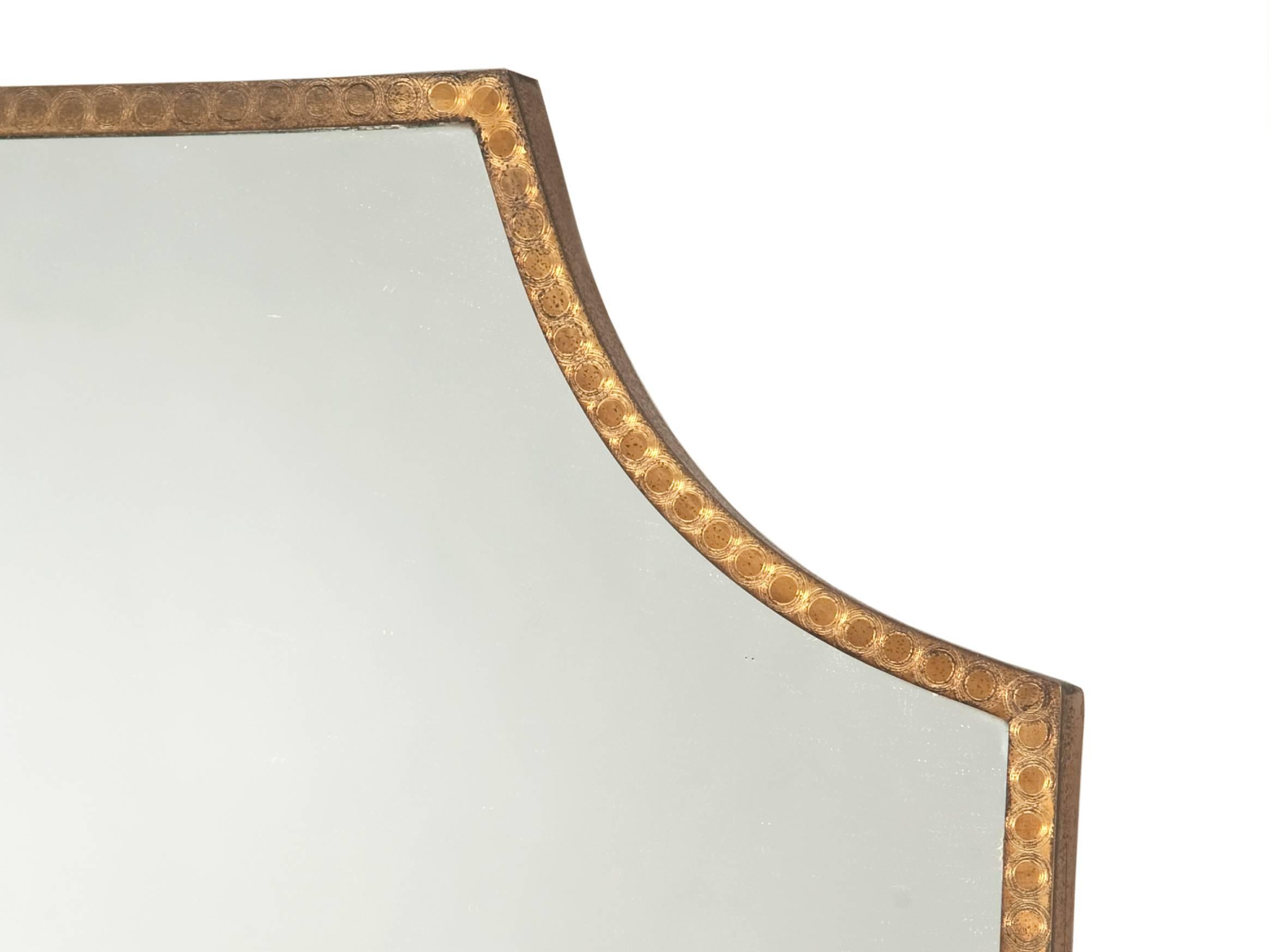 Shield shaped wall mirror with brass frame, Italian design.