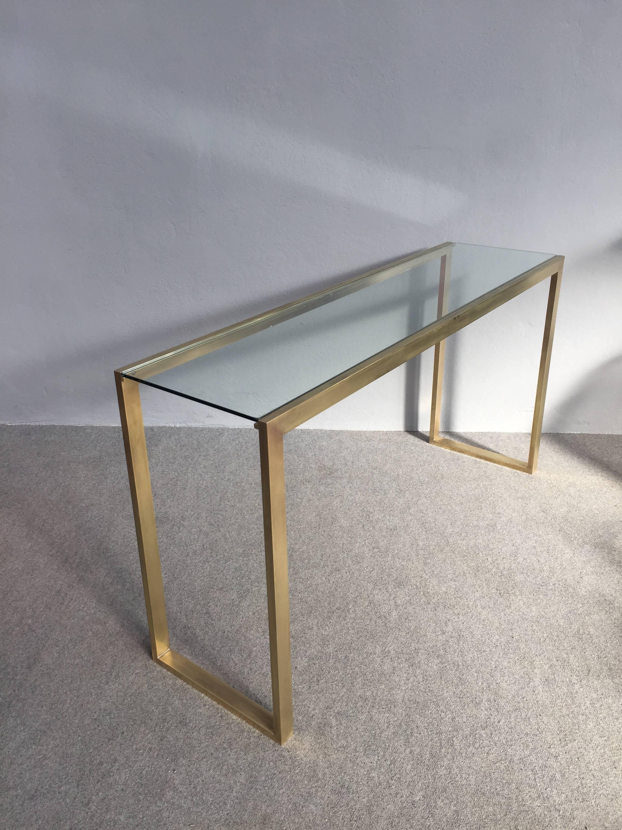 Elegant console table made with solid brass and with glass top.