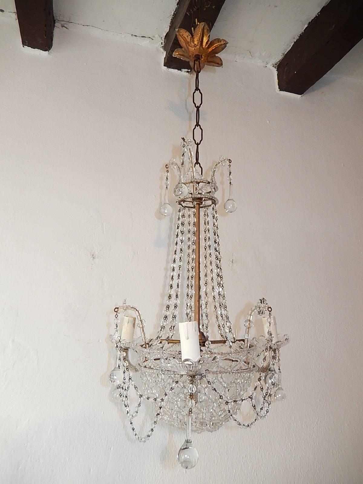 Housing four lights, rewired and ready to hang. Gilt metal body with beading throughout. Crystal beaded basket on bottom with crystal spear in center. Adorning nine Murano clear drops.