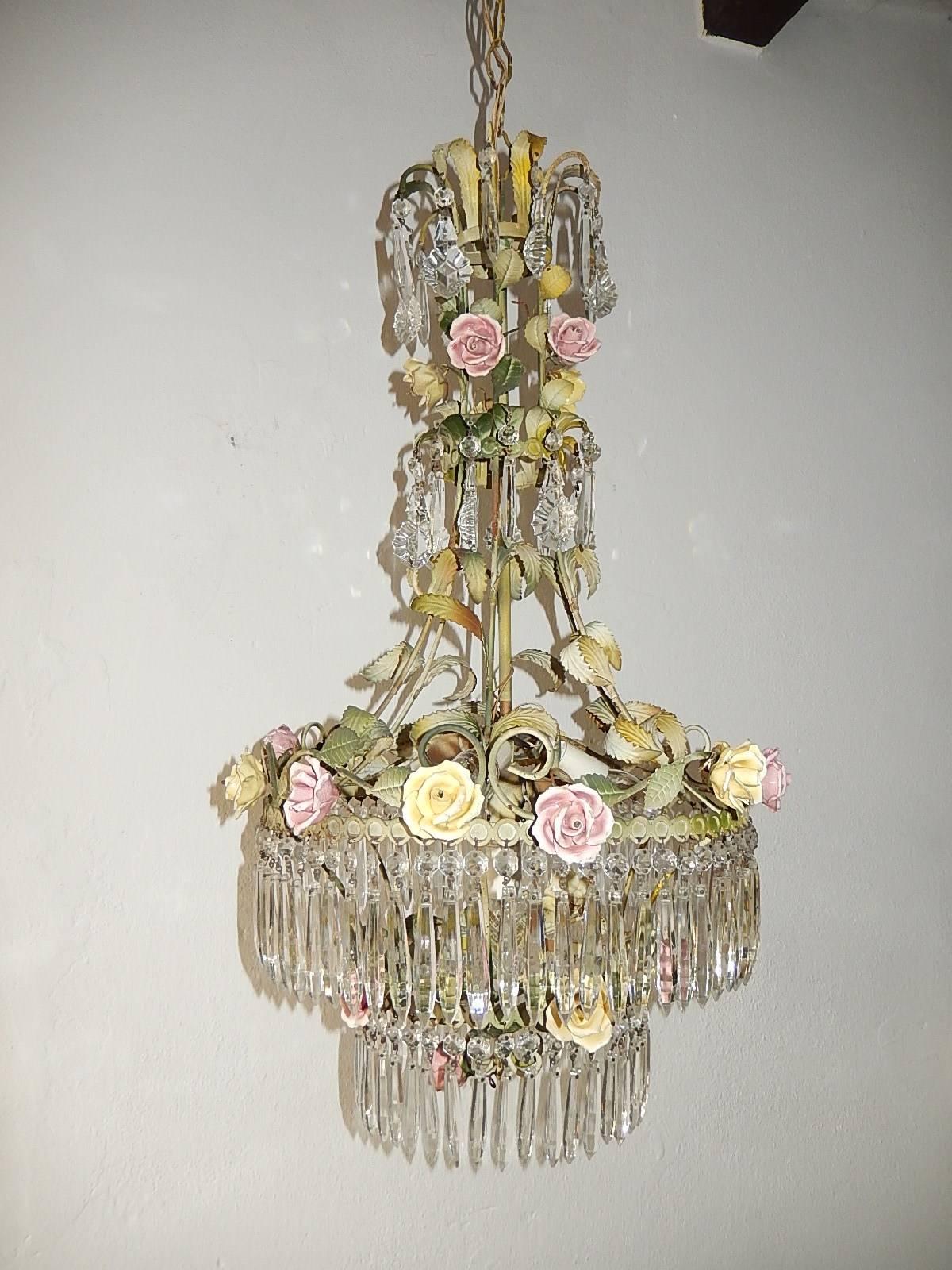 Housing four lights. Original color tole with porcelain roses in pink and yellow. Matching sconces available. Rows of vintage rare shape crystal prisms. Re-wired and ready to hang. Adding another 13