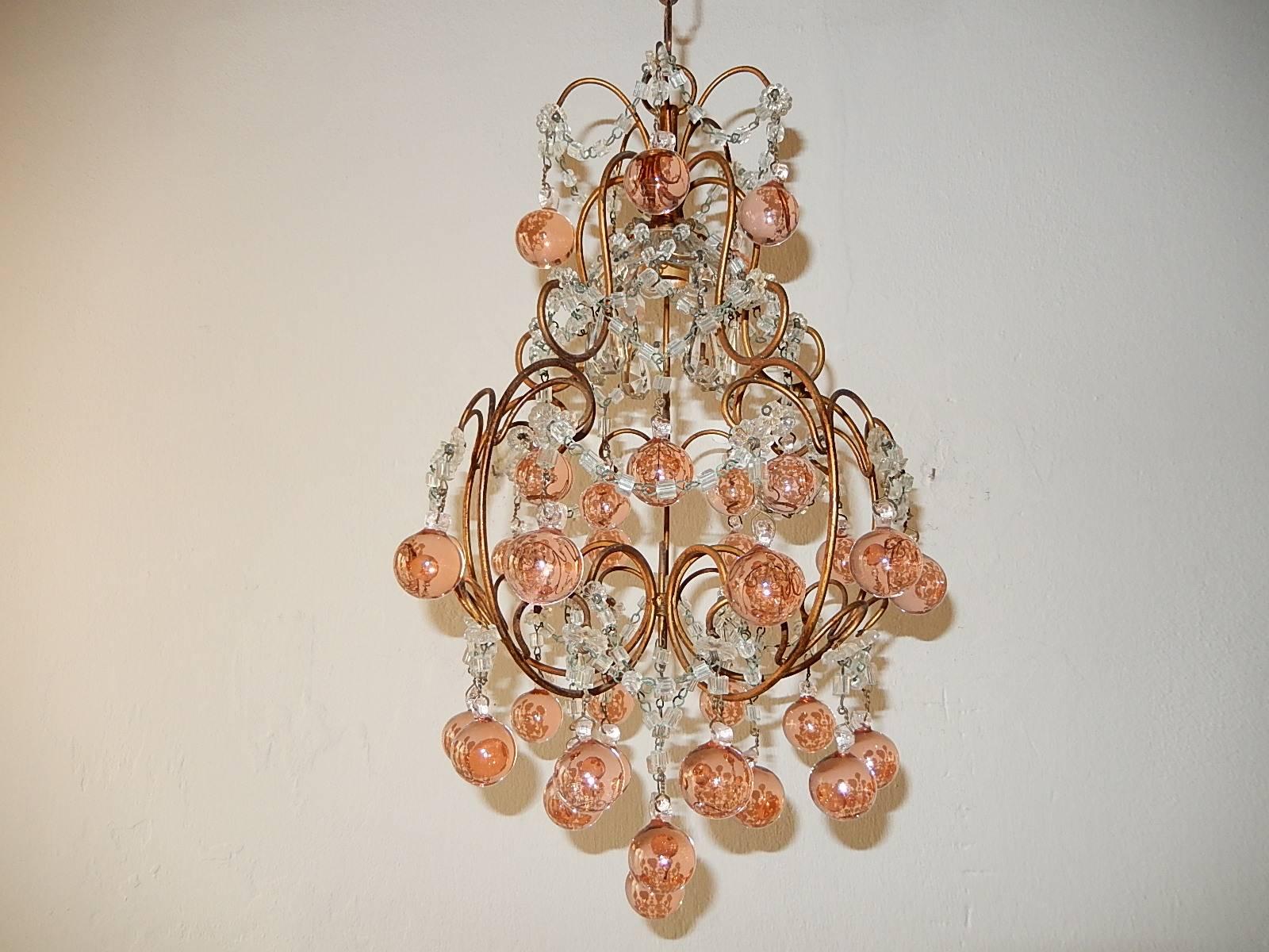 Housing one light under a crystal bobeches, dripping with vintage crystal prisms. Re-wired and ready to hang! Gilt metal with glass florets and macaroni beading swags throughout. Adorning rare pink Murano Bulbous balls. Adding 10 inches of original