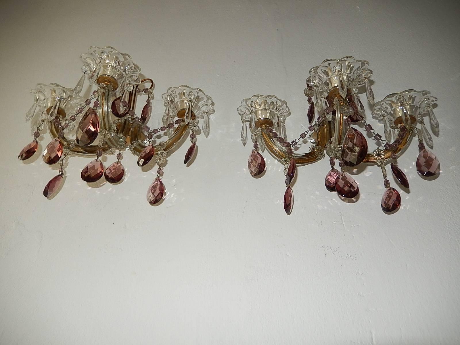 Housing three lights each, sitting in crystal bobeches with vintage crystals. Rewired and ready to hang. Gilt metal arms with Murano glass covering. Adorning purple crystal prisms and matching macaroni swags. Free priority shipping from Italy.