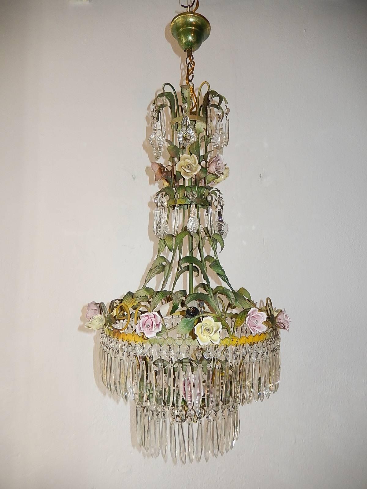 Housing four lights. Original color tole with porcelain roses in pink and yellow. Matching sconces available. Rows of vintage rare shape crystal prisms. Re-wired and ready to hang. Also original chain and canopy still intact. Free priority shipping