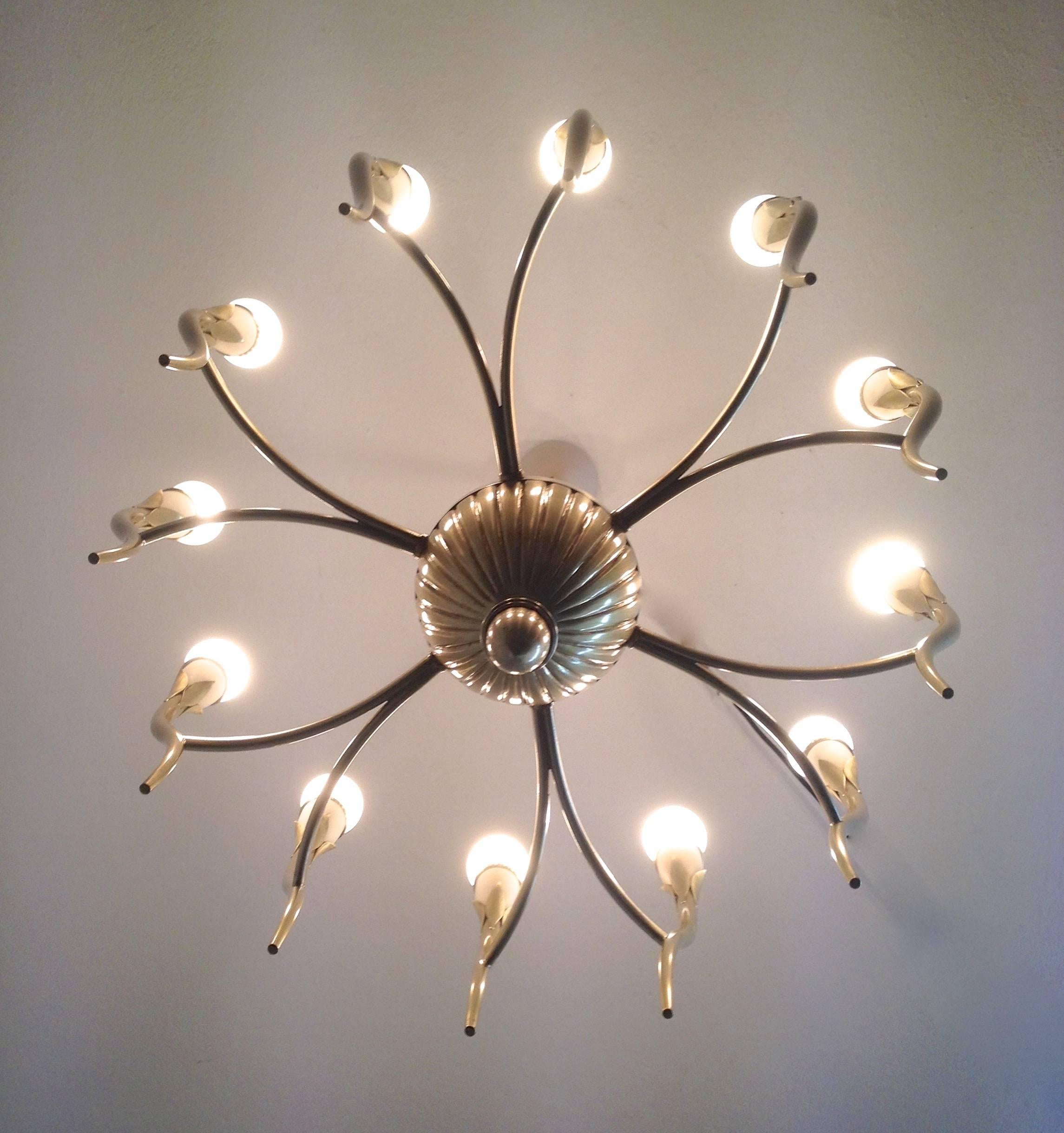 Six arms and twelve lights on curved thin lined sconces held together by the acorn shaped regency style center. This important Mid-Century Italian chandelier is quality made. The light fittings are made of lacquered metal as well as the ceiling
