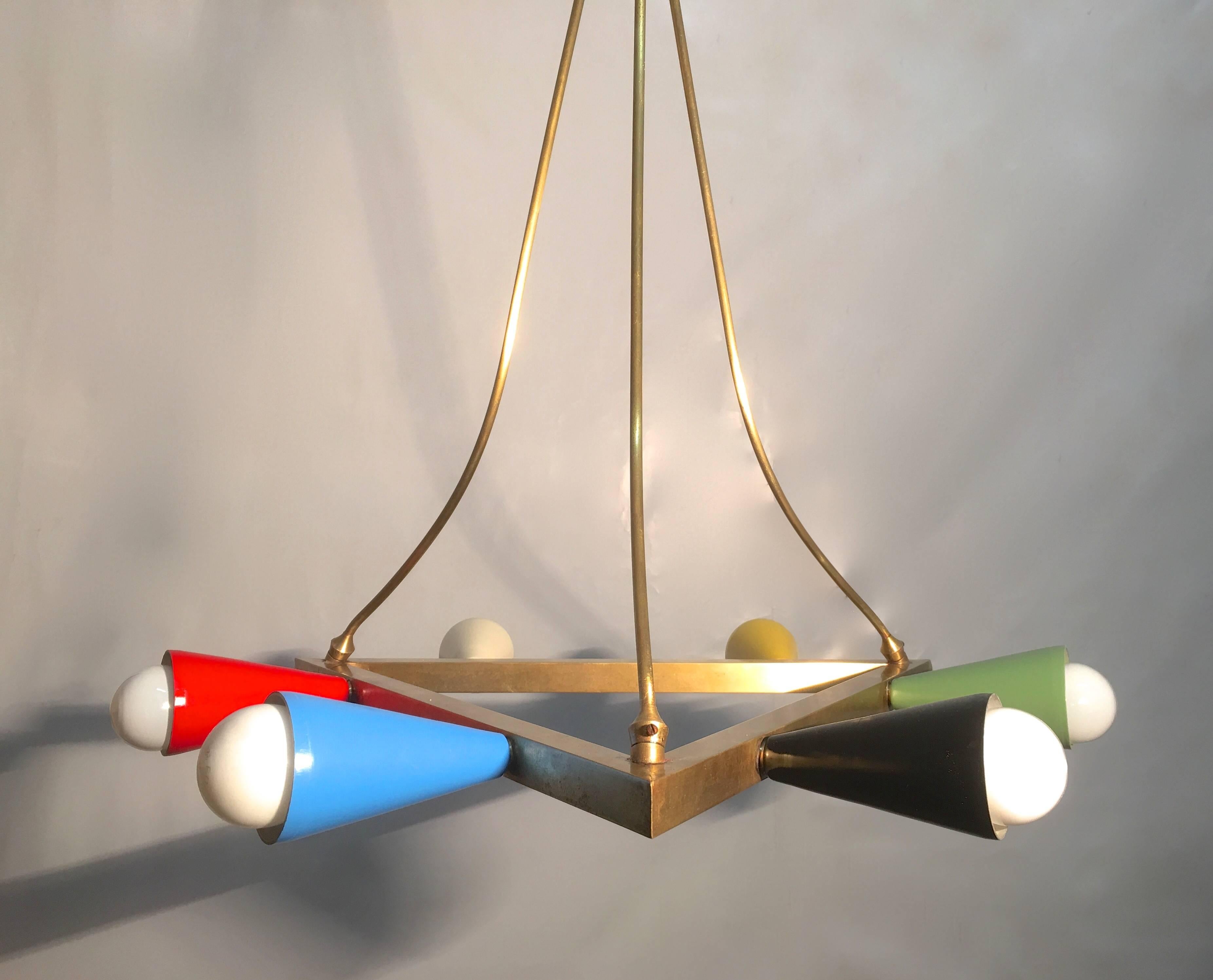 Unusual chandelier with a centre brass triangle on which colored sconces are mounted. Suspended from brass arms that appear to be hanging loosely from its center canopy held by a straight rod and ceiling canopy, this chandelier has many interesting
