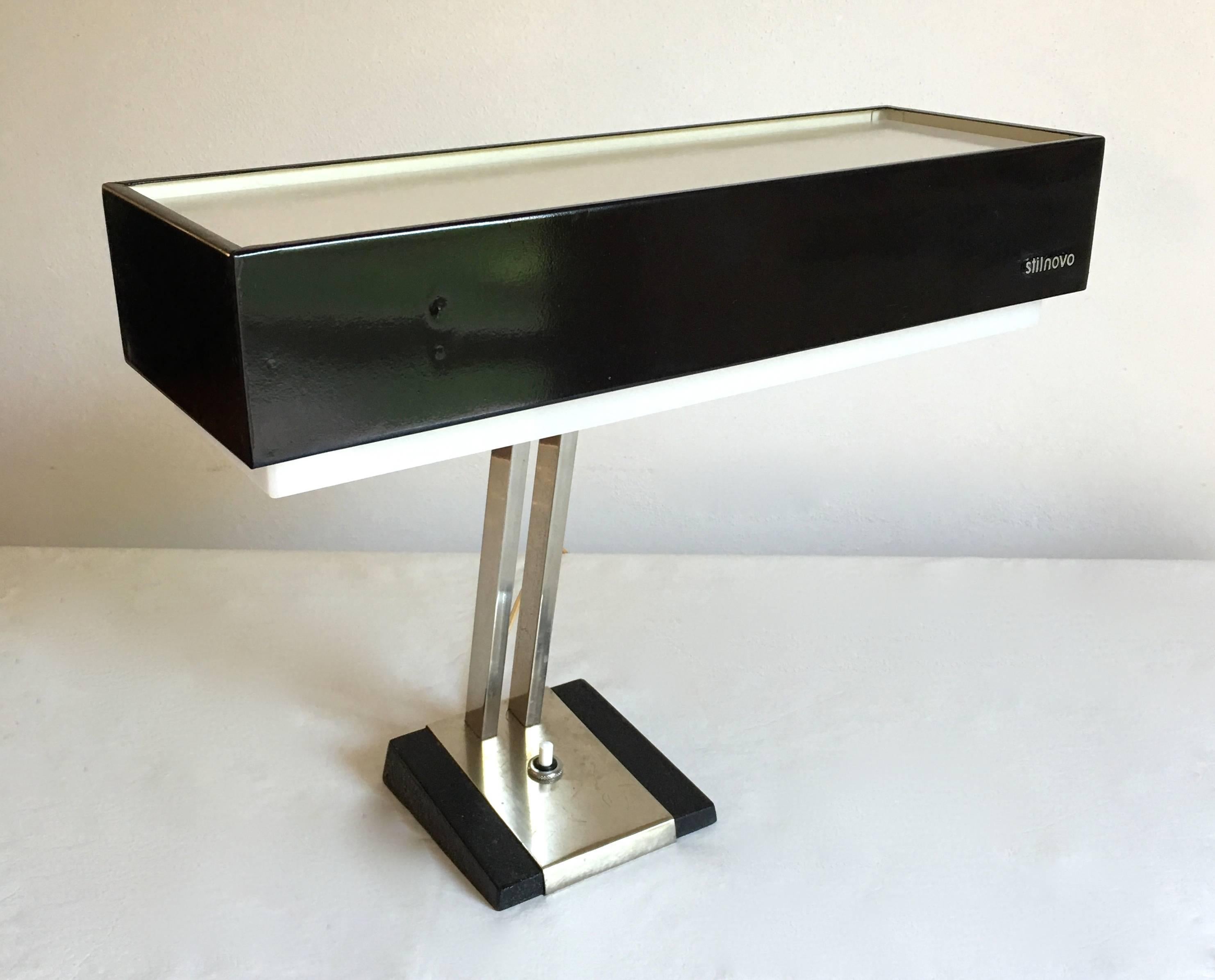 Industrial style masculine desk lamp by Stilnovo manufactured in the 1960s.

Black metal shade with perspex diffuser and set on a chromed double-arm and base.

Very soft light.

It has its switch on the base.

Marked “Stilnovo” on the front