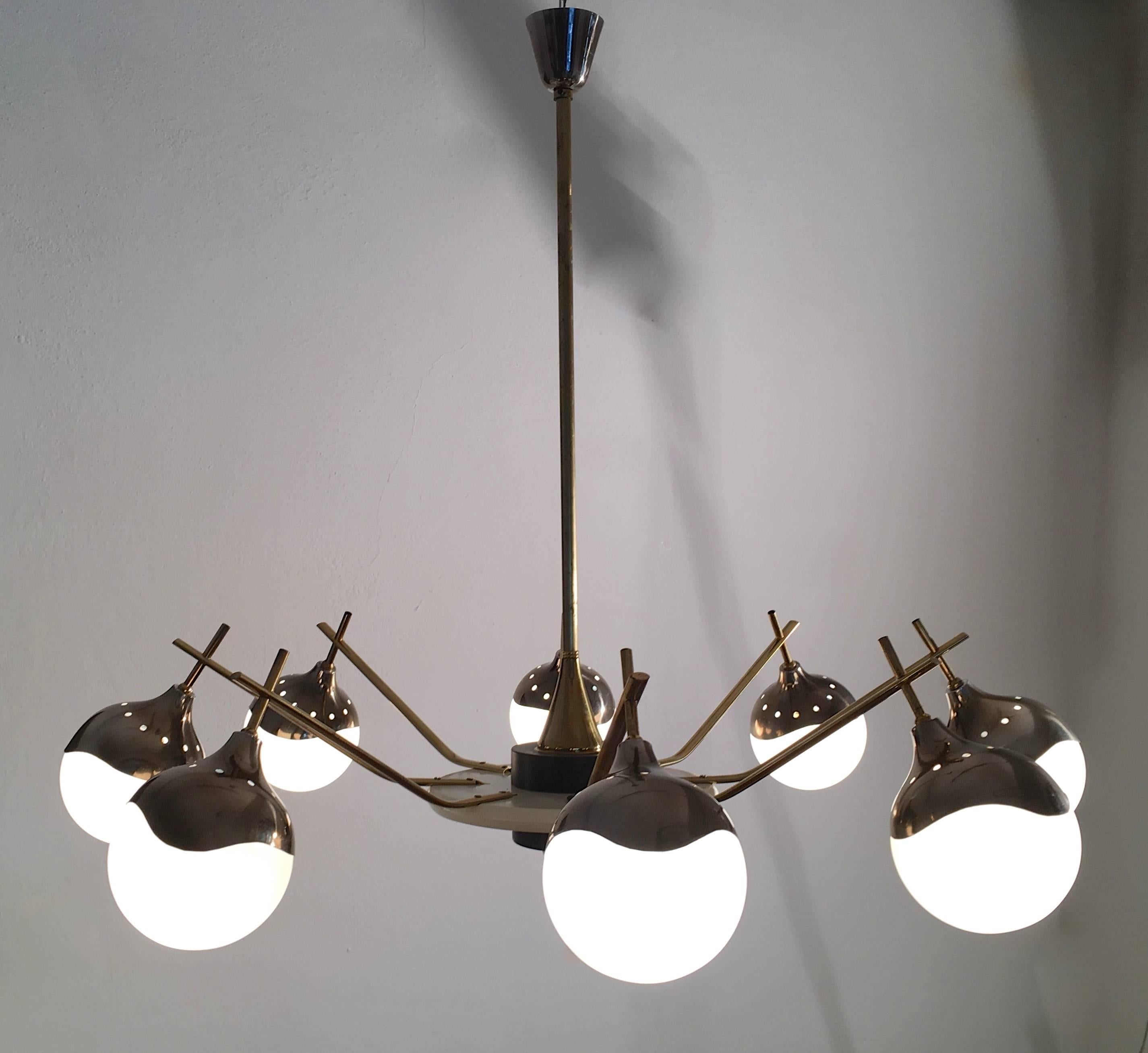 Mid-Century spider chandelier with elegantly curved metal caps holding opaline glass globes. Painted wooden centrepiece and eight brass arms that interconnect with the suspension of the metal caps.