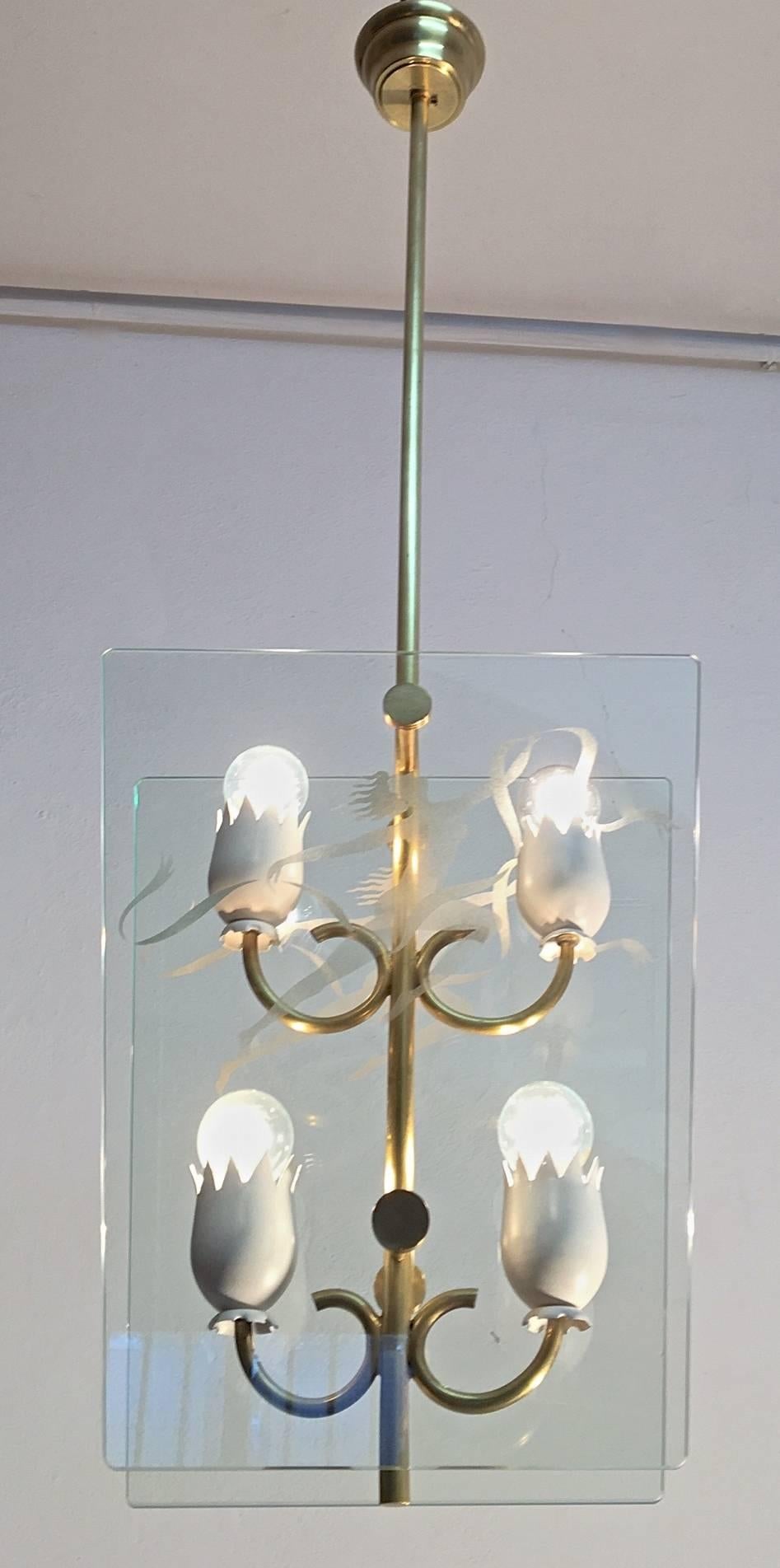 A Mid-Century, Italian pendant in glass and brass with an etched dancing figure. (vetro sabbiato).
Four lights with white metal flower shaped holders and elegant curves.
 