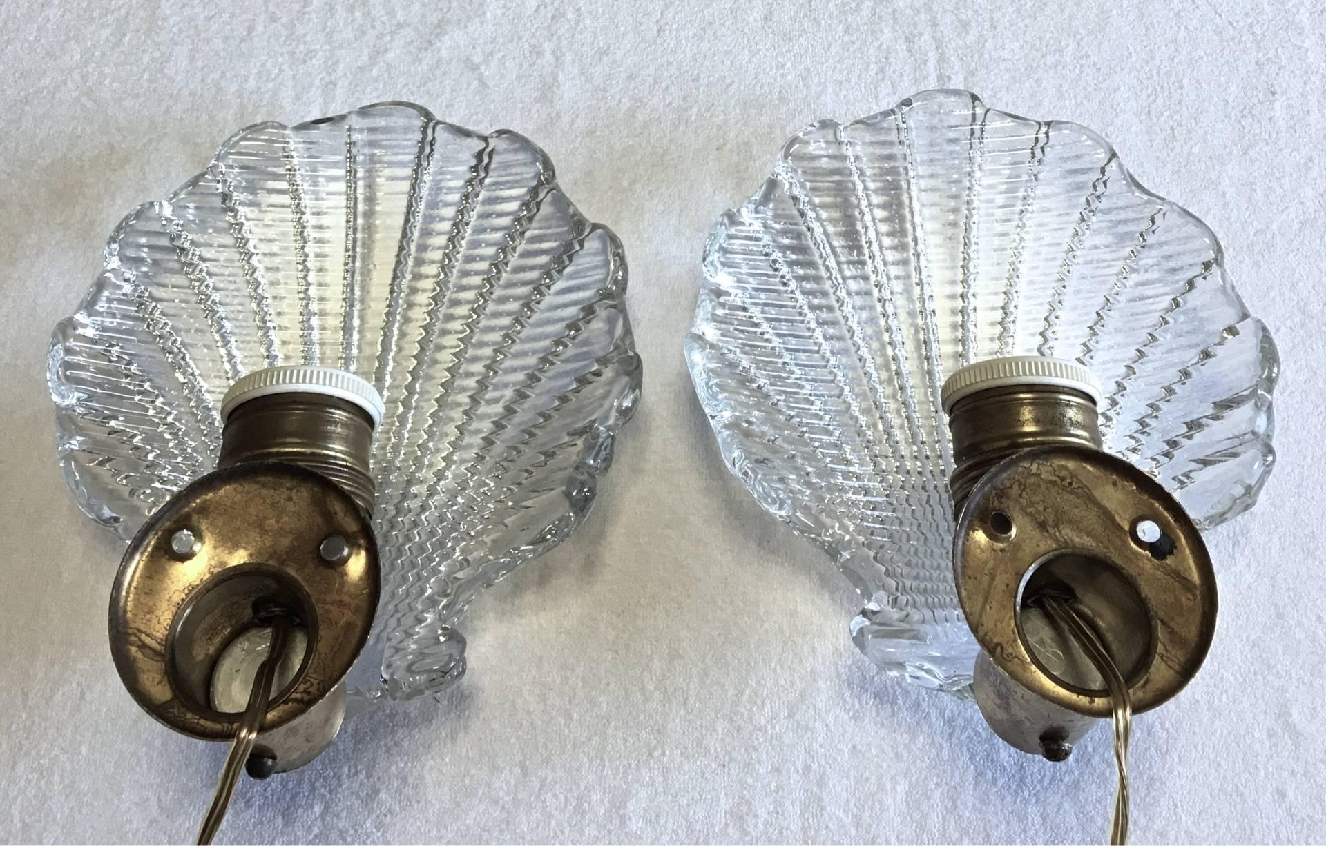 Italian Mid-Century regency style wall lights in shell design with brass fixture and handblown Venetian glass diffusers.