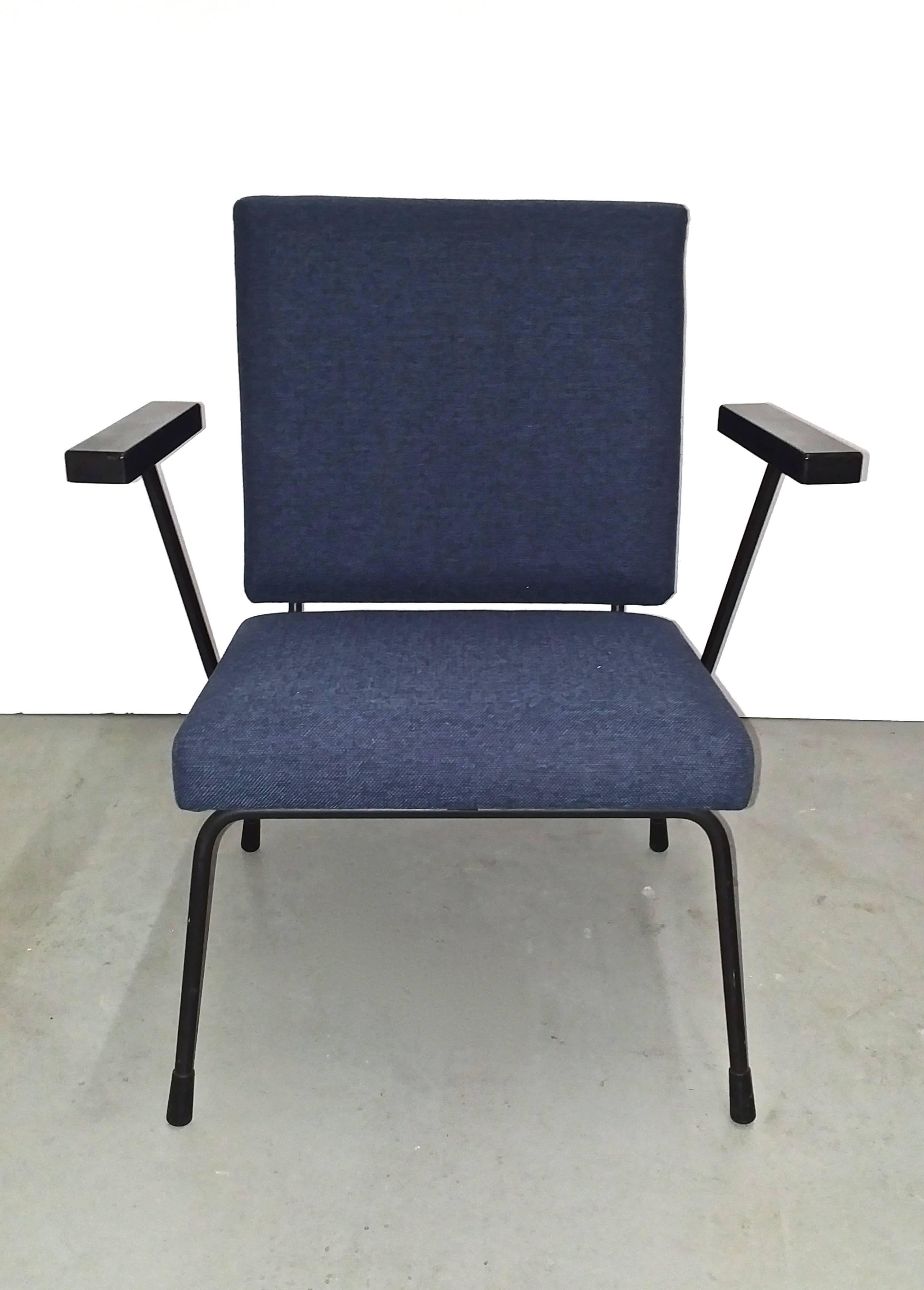 This Classic 1407 chair was designed in 1957 by Willem Rietveld and Andre Cordemeyer for Gispen, The Netherlands. It features blue Kvadrat upholstery, a black metal frame, and Bakelite armrests.