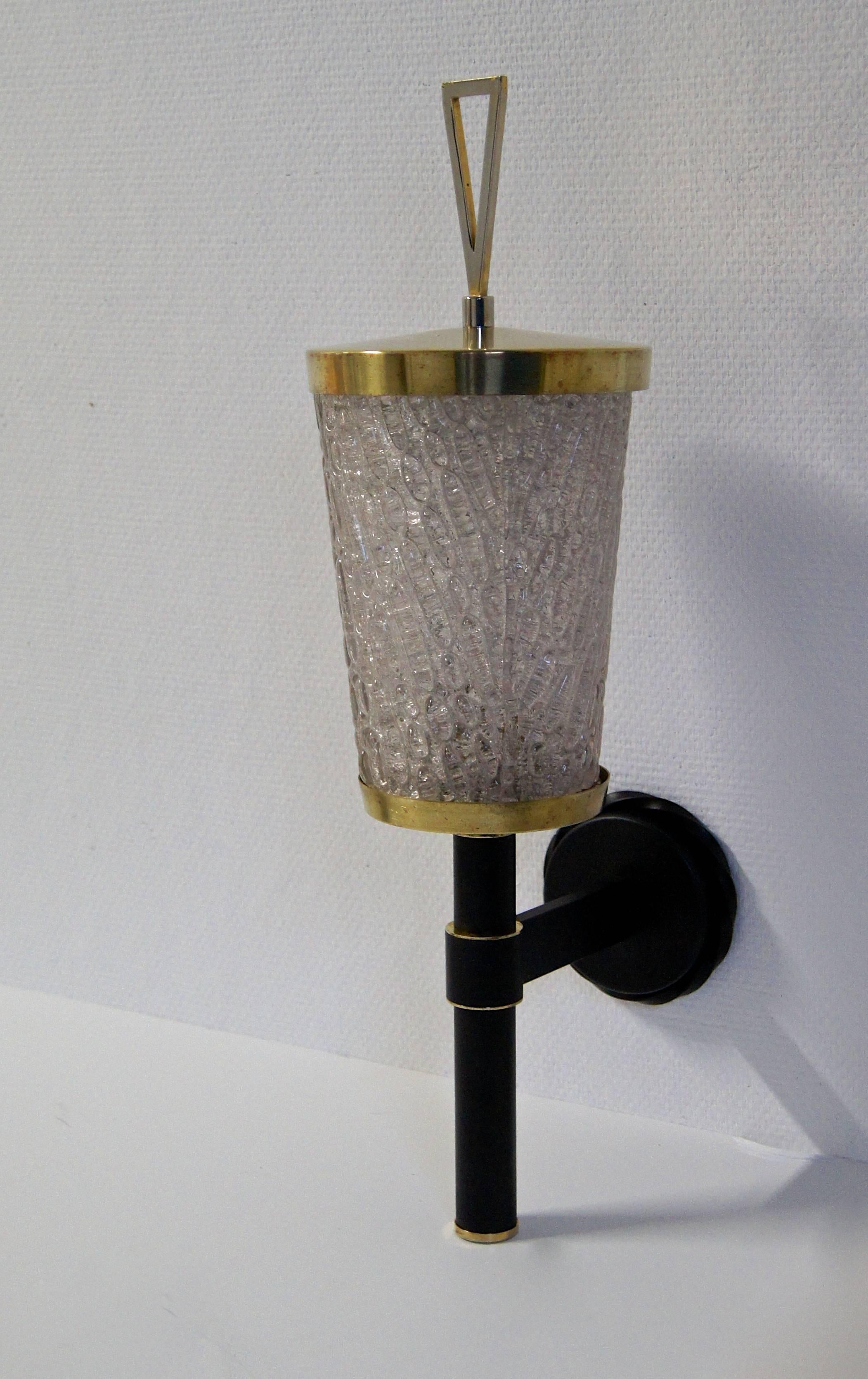 A Mid-Century French wall light with a very thick textured diffuser. The brass top has a modernist design. The black wall mount has brass details and has a high quality finish.