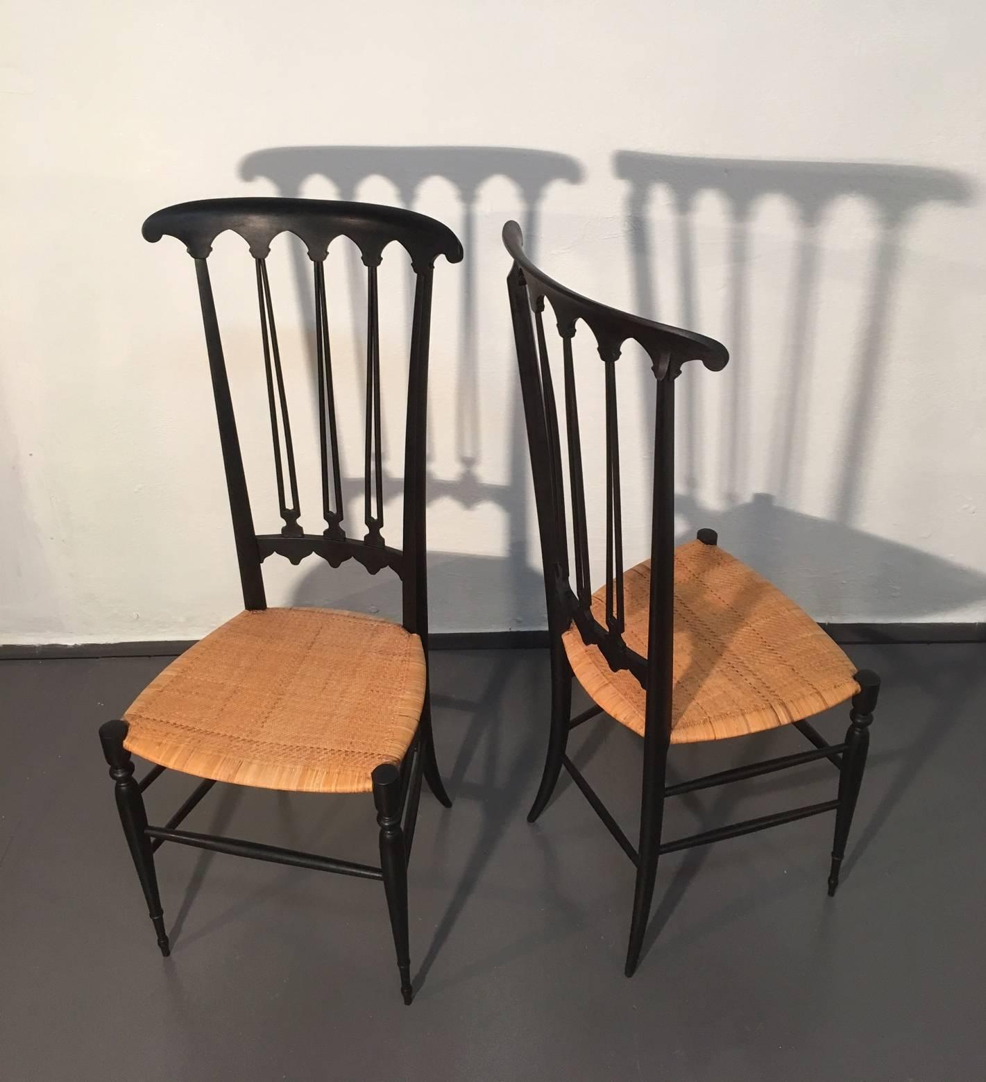 Lovely pair of Chiavari chairs of ebonized wood. Detailed high backrest with double spine and curved legs.