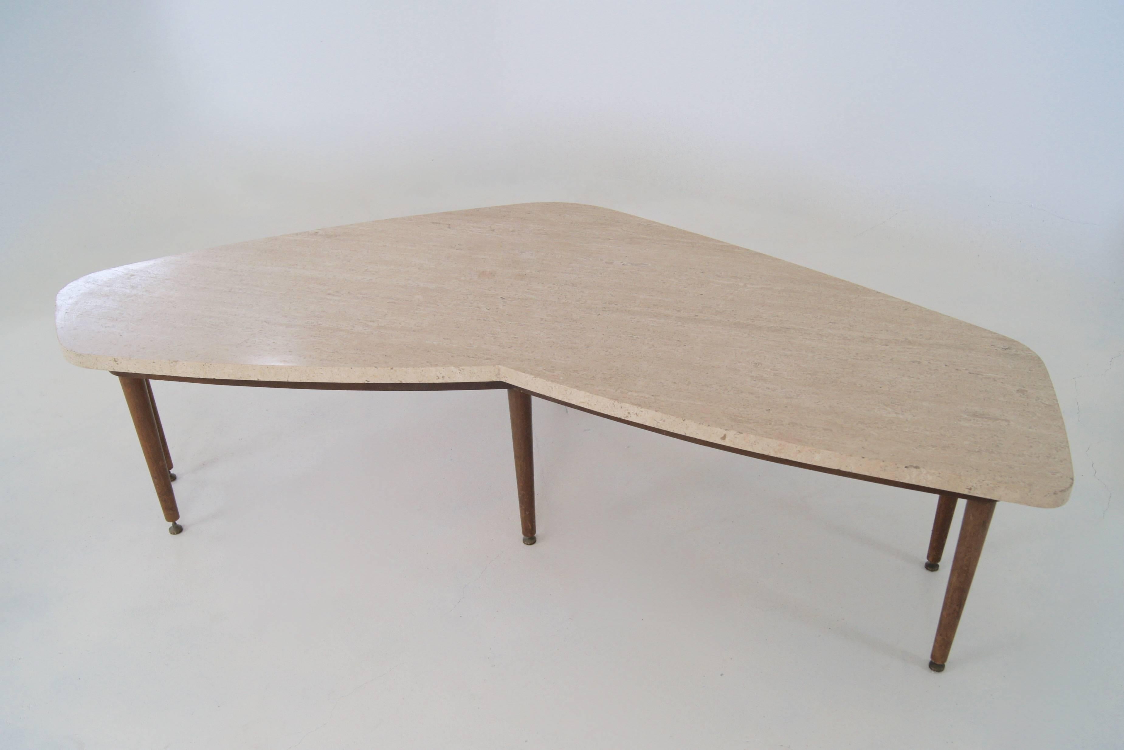 Free-form or angular kidney shaped table with travertine top on a wooden base with six legs. The legs have height adjustable brass feet. The sculptural design with nice details. Reminds of shapes often used by Gio Ponti.