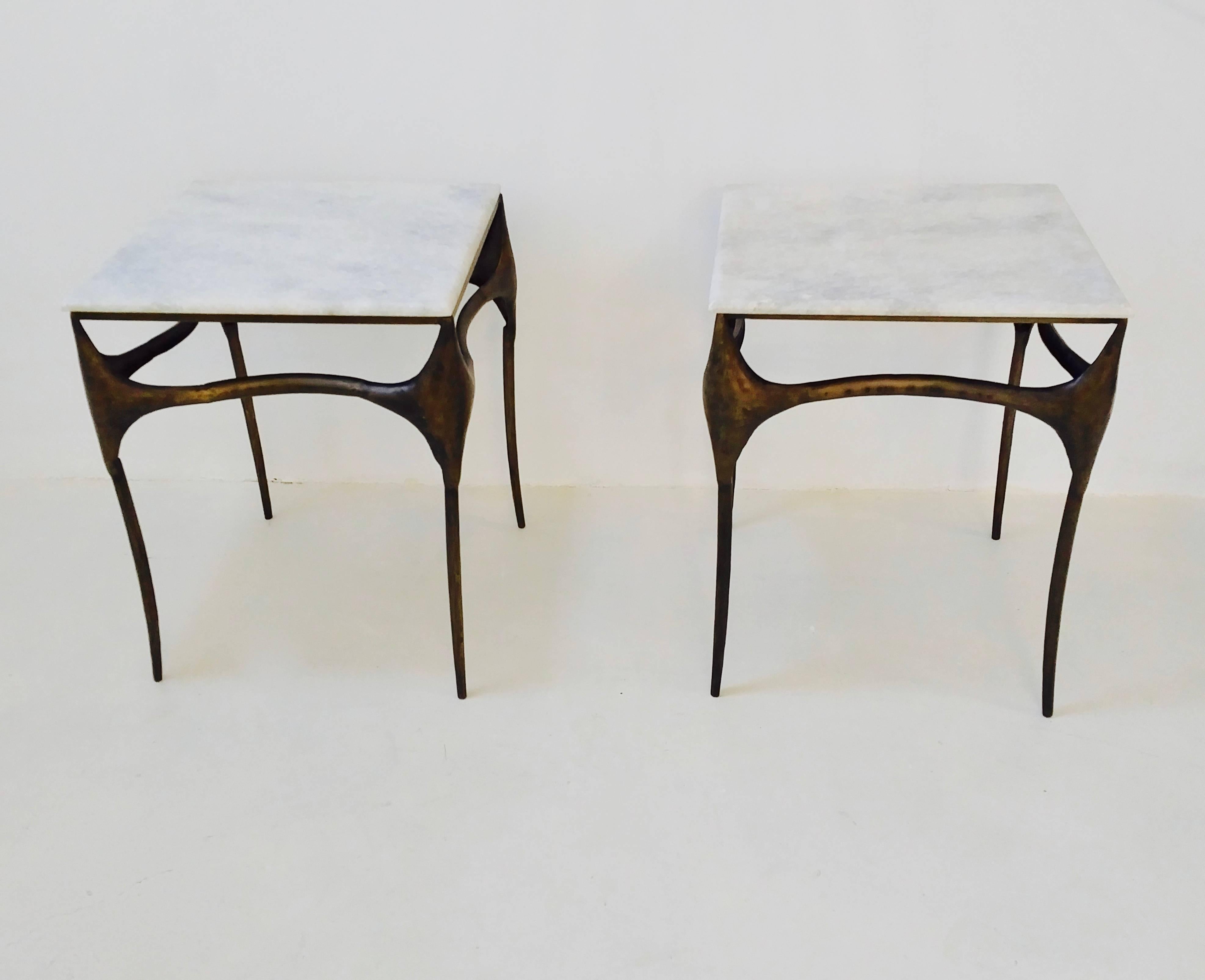 Pair of elegant side tables with a white marble top and bronzed metal frame. The organic shaped legs and rest of the base lends the table a certain lightness and elegance.
 