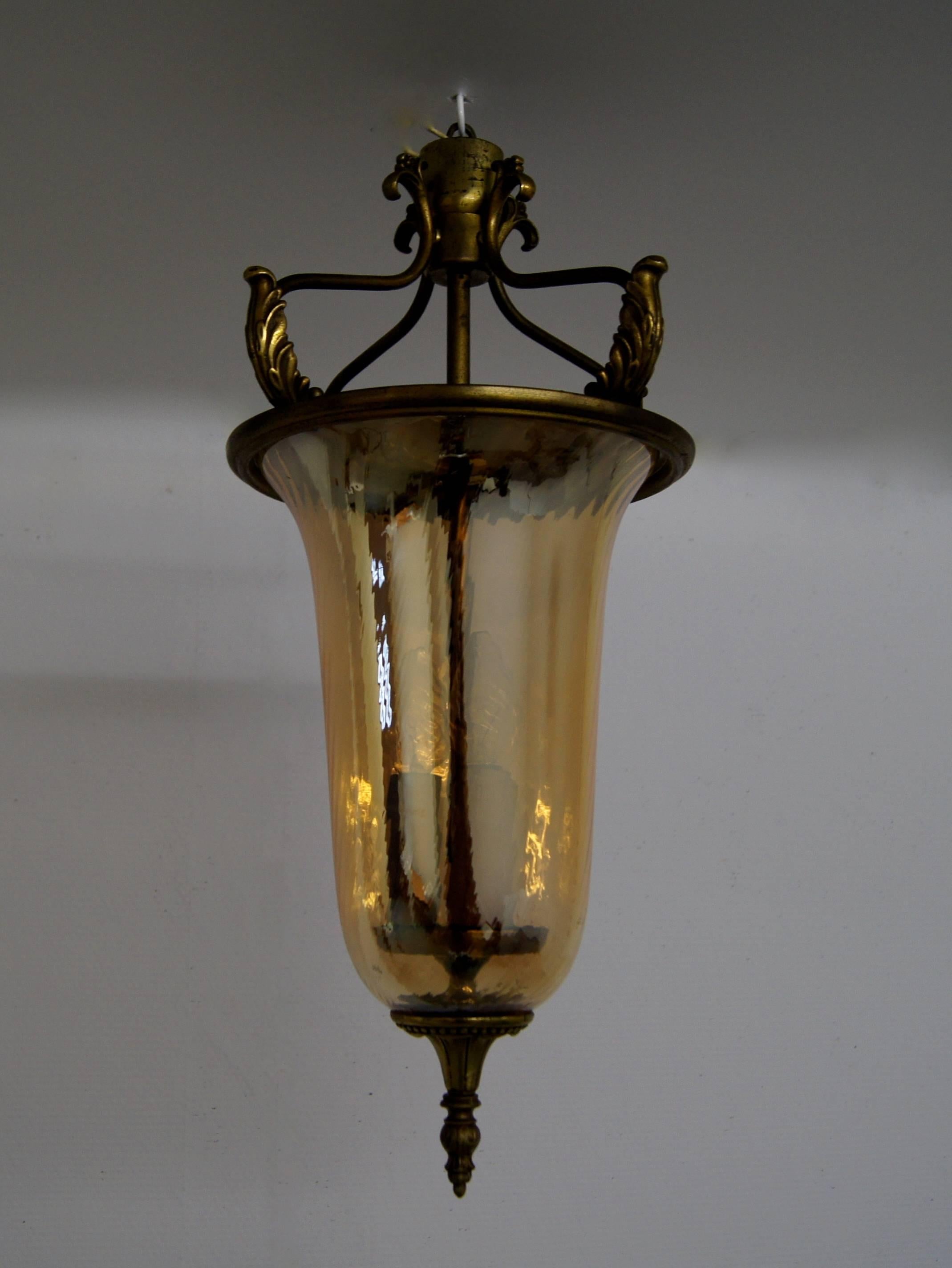 Very elegant and rare Venetian pendant form the 1940s with gold colored glass which has a slight style twirl. The suspension is made of brass with four turned up brass leaves held by its four bent arms that come together holding the middle section