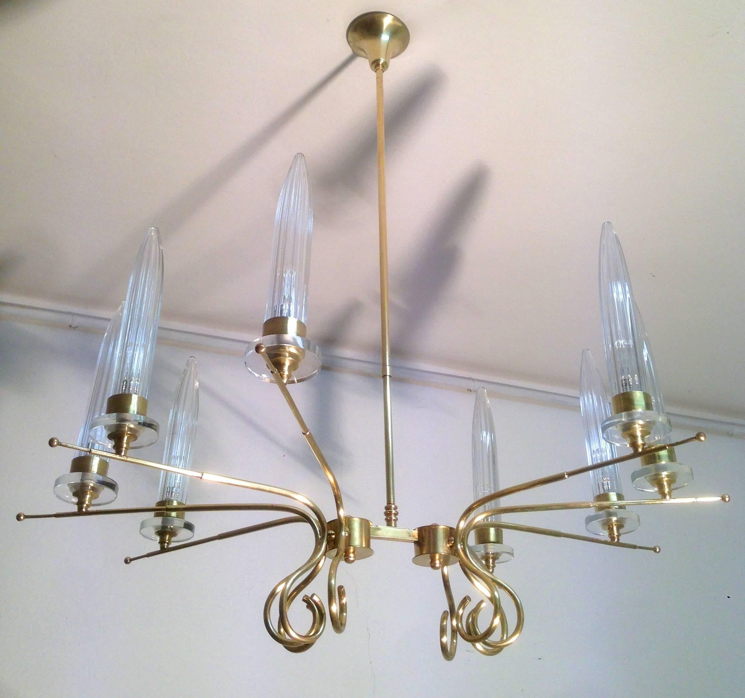 Very decorative and high quality brass and Murano glass chandelier.
The middle section divides the lamp in two sections where the brass arms stand out creating a wide Sputnik eight-arm chandelier. The handblown glass shades Stand like candles on