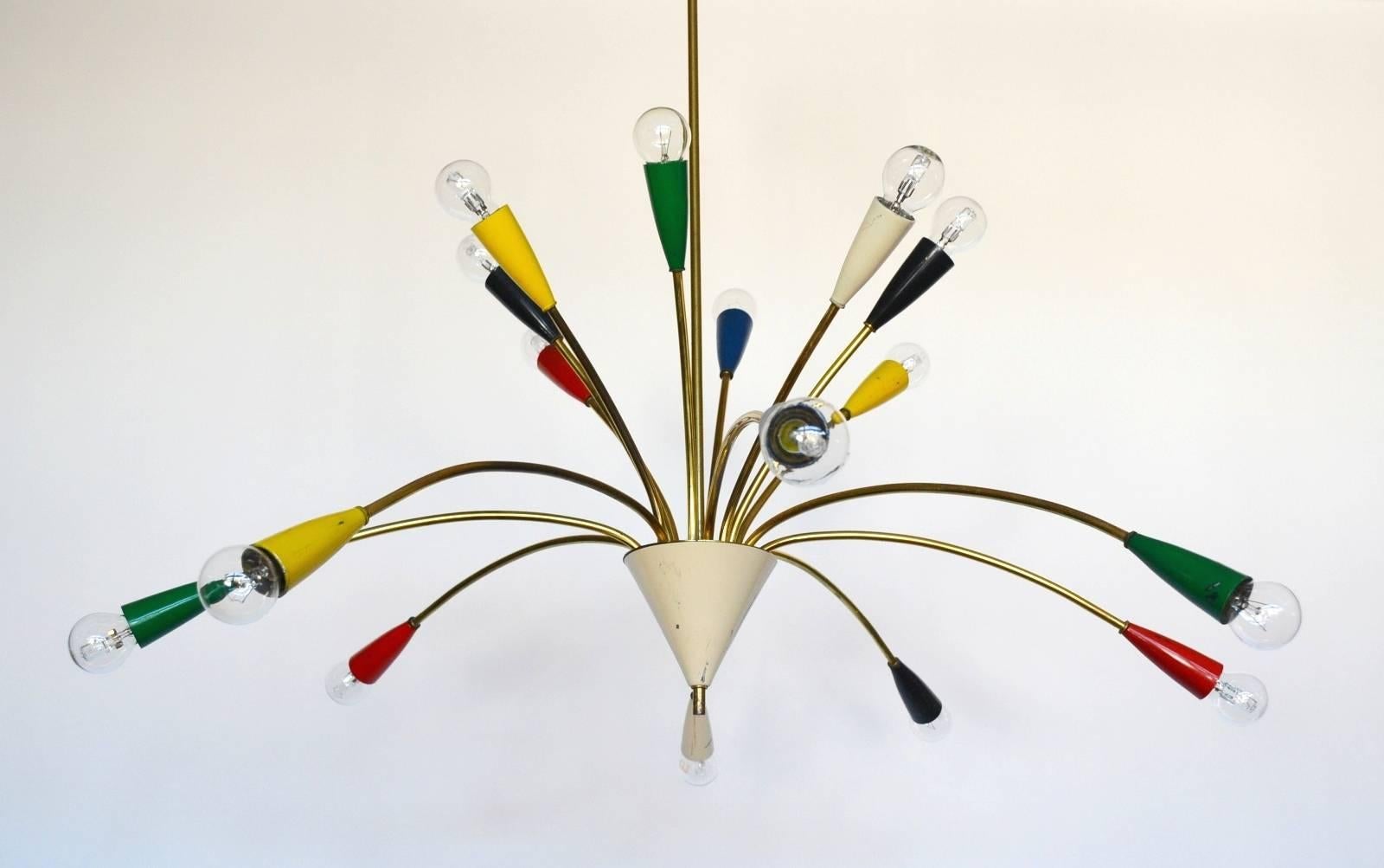 This highly attractive and quality brass and color painted chandelier has sixteen arms. Eight up lighters and eight down lighters. They create a sunburst of light. In its original condition with original paint.