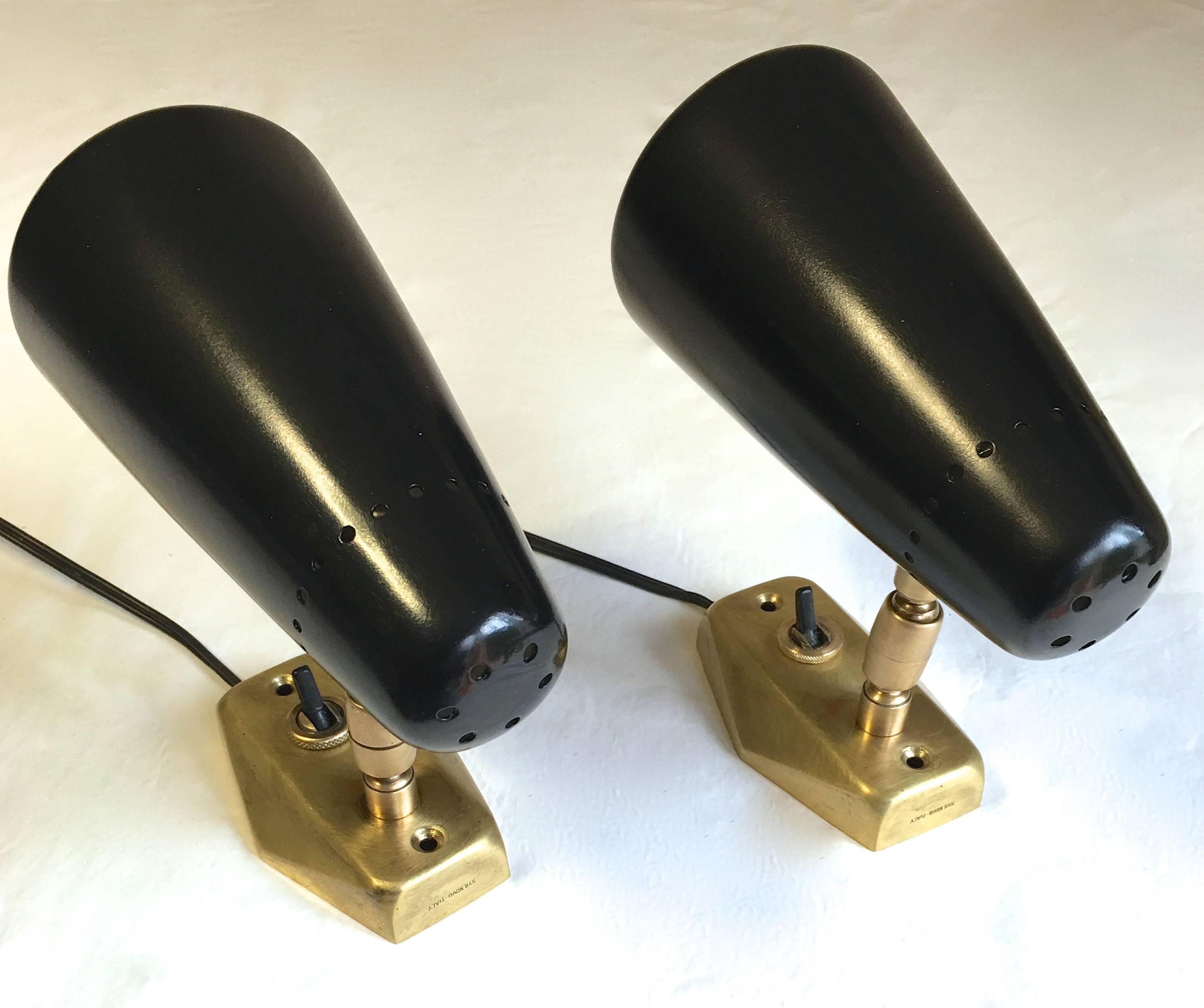 A pair of highly attractive Stilnovo wall lights in black painted metal with white interior on a articulate brass base with switch. The lights rotate in height and angle. Original label in the interior of the shade and signed on the base.

Base: 9