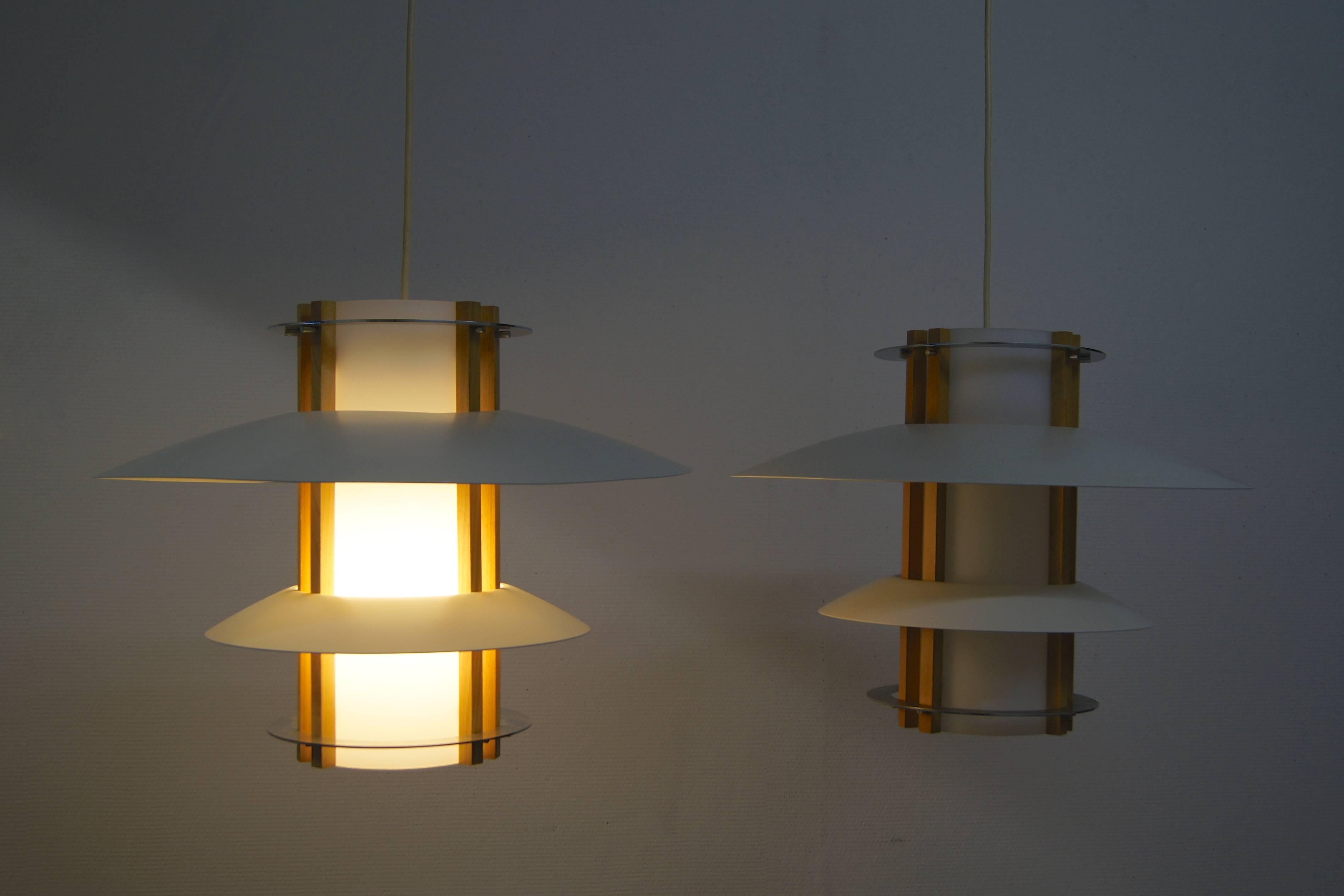 These lamps with metal saucers in off-white rest on metal bolts and enclose an acrylic diffuser with light wooden rods. Two steel rings are placed on the bottom and top. Originally from a church in Sweden this design has a slight Asian feel and they