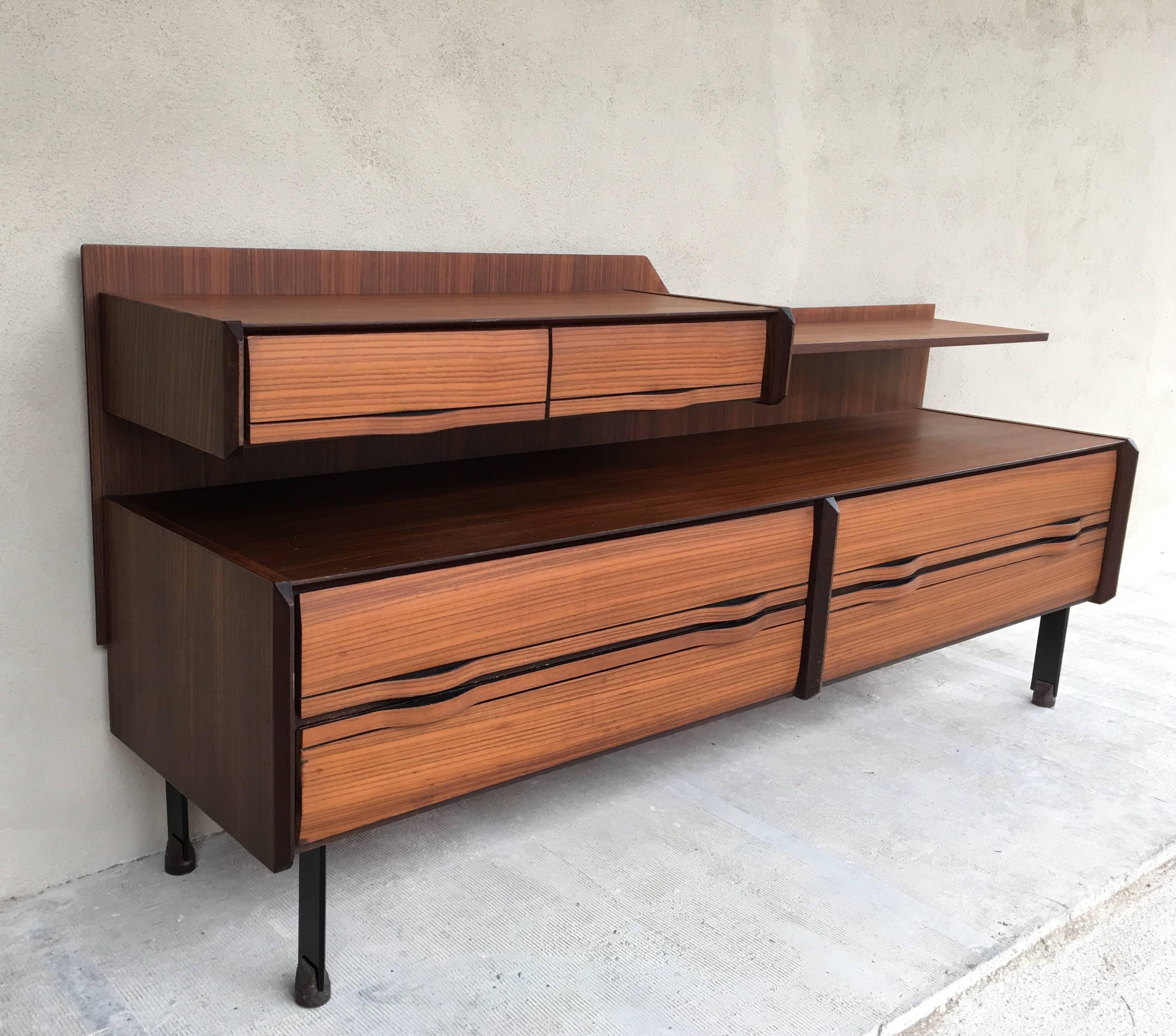 A wonderfully crafted sideboard from teak with an upper tier with two drawers and shelf and four larger drawers on the lower tier. Black lacquered steel legs. The bentwood handles that are an integral part of the drawers are a beautiful detail. Good