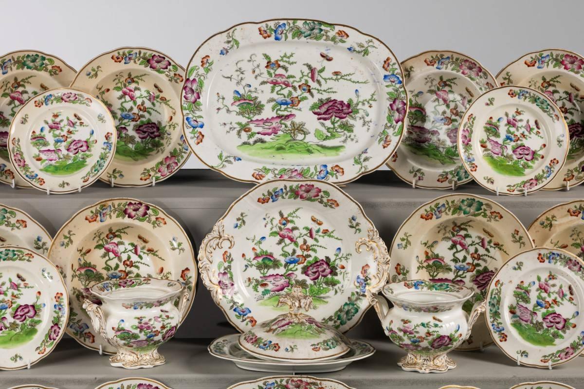 An English mid-19th century porcelain part dinner service of oriental design. With exotic flowers and foliage. 

10 x 10 inch soup bowls.
12 x 9 inch dessert bowls.
2 x tureens (complete).
2 x small tureens (no lids).
2 x oval dishes.
13 x 10