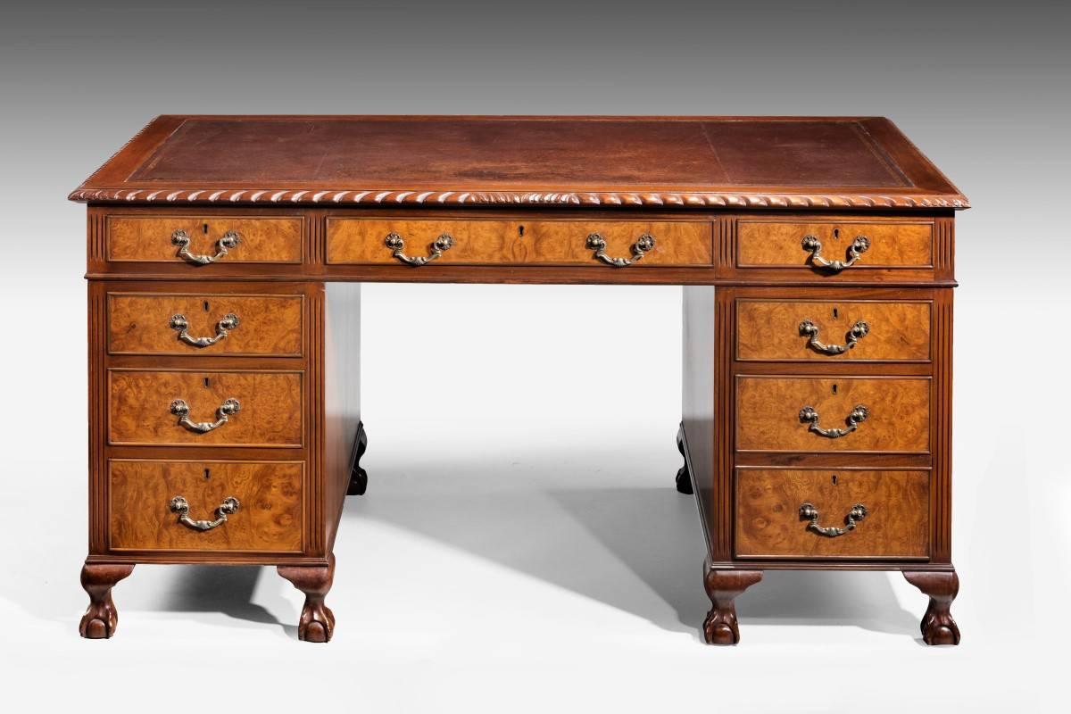 A very highly figured mahogany pedestal desk on short cabriole legs with claw and ball supports. Attractive and original cast swan necked handles. The top with a gadrooned continuous border and an inset leather top, the top being original.