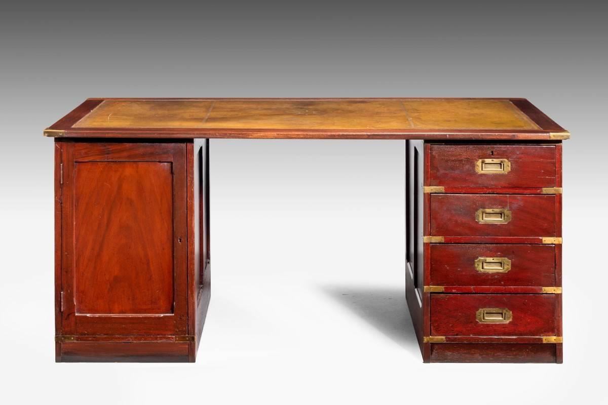 A mid-20th century three section pedestal desk. The right hand side fitted with military handles and a cupboard to the left hand side. Hand tooled inlaid green leather gilded top.